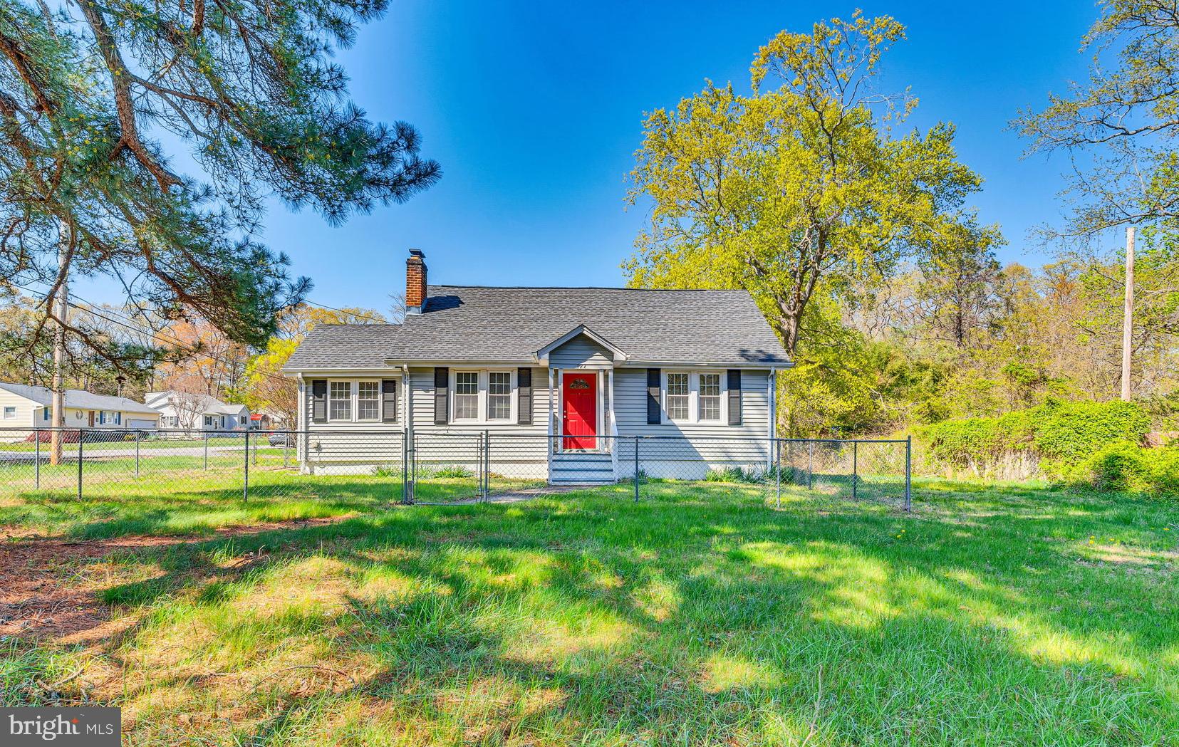Charming and updated Cape Cod on a lovely corner lot with a fenced yard, private driveway, and two handy storage sheds (sold as is). Step inside to a warm and inviting living room with a brick fireplace, hardwood floors, and a large picture window for plenty of natural light. The remodeled kitchen features updated cabinets, countertops, and a garbage disposal, while the formal dining room offers beautiful wood trim, hardwood floors, and an updated chandelier. There are two comfortable bedrooms on the main level, both with hardwood floors, and one with a ceiling fan. A cozy addition off the family room, currently used as an office, has its own side entrance and carpeting. The rear addition offers vaulted ceilings, a ceiling fan, Berber carpet, and a private back door, perfect as a bonus room or quiet retreat. The updated hall bath includes a decorative vanity, designer lighting, and a tub and shower combo with ceramic tile. Upstairs is a spacious, open room with knotty pine walls, hardwood floors, and plenty of lighting, great for guests or hobbies. Enjoy peace of mind with double-pane thermal windows, a newer architectural shingle roof, and vinyl-wrapped exterior. Relax on the back deck and admire the large, beautiful pine tree in the front yard. This well-maintained home is ready for you to move in and enjoy. 1st Time Home Buyers can enjoy 100% Financing with the USDA loan.