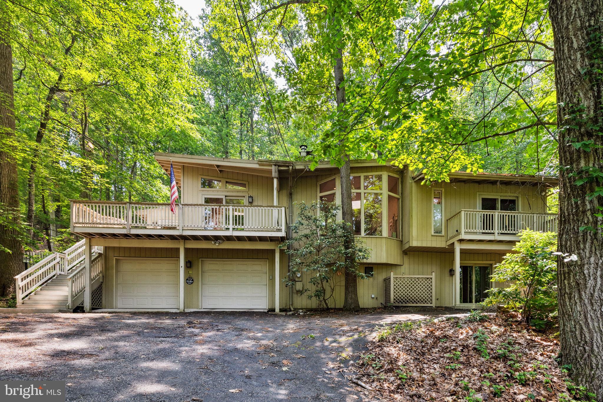 Tucked into the wooded serenity of one of Wayne’s most picturesque neighborhoods, 100 Pugh Road is a striking hillside residence that artfully blends contemporary architecture with a deep connection to nature. This custom home is the work of noted architect Paul L'Esperance. Surrounded by mature trees and lush landscaping, this thoughtfully designed home offers clean lines, flexible living spaces, and a peaceful backdrop for daily life.
Inside, the expansive main living area is bathed in natural light, thanks to soaring ceilings, clerestory windows, and skylights. Anchoring the space is a sunken conversation pit beside a dramatic stone fireplace. This warm and inviting feature is a hallmark of Paul L'Esperance’s distinctive style. The adjacent dining area offers hillside views and opens to a wraparound deck—perfect for indoor-outdoor living. The updated kitchen features crisp white cabinetry and a bright breakfast nook overlooking the surrounding greenery.
The primary suite is conveniently located on the main level, offering a spacious bedroom and a bright, private bath. A bonus space—ideal for an office, reading nook, or nursery—can be enclosed with pocket doors, and a private deck provides a quiet spot overlooking the hillside.
Step outside to a generous main deck nestled among the treetops—ideal for morning coffee, evening wine, or simply enjoying the sounds of nature.
Downstairs, the walk-out lower level offers even more flexibility with a large recreation room, two additional bedrooms, and a full bath—perfect for guests, a home office setup, or multigenerational living. A covered patio and a two-car garage complete the home.
Located just 20 miles from Philadelphia and minutes from downtown Wayne’s boutiques, restaurants, and the SEPTA R5 line, this home offers the best of both worlds: a tranquil retreat with convenient access to everything. Add in its location within the award-winning Tredyffrin-Easttown School District, and you have a home that’s as practical as it is beautiful.
A design-forward gem in a beautifully wooded corner of the Main Line—100 Pugh Road is ready to welcome you home.