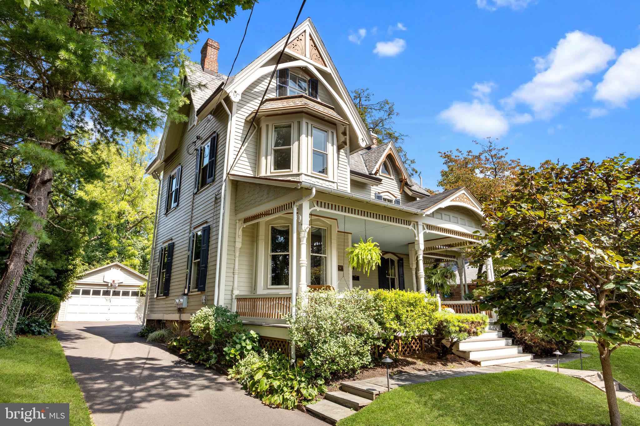 This beautifully updated Victorian blends timeless period details with today’s modern conveniences. A welcoming front porch invites you to relax with your favorite beverage as neighbors pass by - an ideal spot for holiday parade viewing.
Inside, the graceful entry foyer showcases exquisite millwork and architectural character. A thoughtfully appointed living room is highlighted by a period fireplace surround, and classic bay window alcove. The spacious dining room, perfect for gatherings and celebrations, adjoins the thoughtfully updated kitchen. Custom William Draper cabinetry, artisan backsplash with medallion detail, leathered granite countertops, a porcelain farm sink, and stainless-steel appliances are featured in the gourmet kitchen with peninsula seating opening into the bright family room addition. Triple glass doors frame panoramic views of the expansive rear property and lush gardens, creating a serene retreat. Enjoy morning coffee or host al fresco gatherings on the stone patio, thoughtfully designed to harmonize with the landscape.
A classic center hall staircase, or convenient rear stair, leads to the spacious second floor, where the owner’s suite offers a classically appointed en-suite bath with oversized tub/shower, pedestal sink and generous linen closet. Two additional nice size bedrooms and modern hall bath complete this level.
On the private third floor, a pointed-arch stained-glass window graces the front gable. Two additional bedrooms, one recently used as a home office, plus a large storage room make this space both charming and functional.
Modern convenience meets classic style on the main level with a mudroom and laundry, perfect for seasonal and sports gear. From here, access the detached garage, which provides even more storage, in addition to the home’s lower level.
Move right in to this meticulously maintained home and enjoy all the amenities of in-town living. Stroll to the acclaimed restaurants, charming boutiques, the community library, playgrounds, and local theater offering a tremendous array of programing. Enjoy holiday parades and hometown festivals in a vibrant small-town setting, while being minutes to commuter rail and major highways to Philadelphia, Princeton and New York.