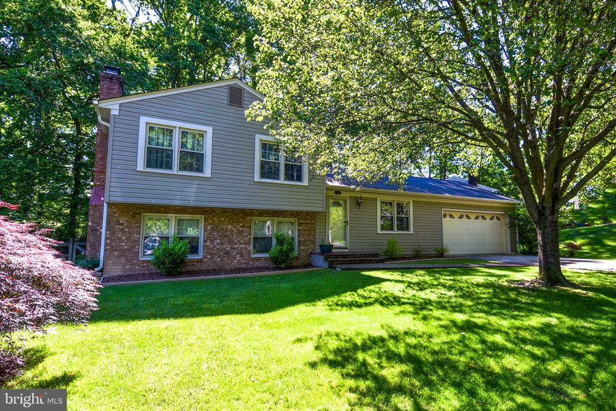 VA assumable loan in place, offering an opportunity for qualified buyers! Beautifully updated 3-bedroom, 2-bath, single-family home with a 2-car garage equipped with a level 2 charger in the sought-after Lake Ridge community. Enjoy the backyard being spacious, providing a serene environment that is perfect for both entertaining and enjoying peaceful outdoor moments. The renovated kitchen features a central island, granite countertops, stainless steel appliances, and a stylish tile backsplash, ideal for entertaining with an open flow to the living and dining areas and access to the deck through sliding doors. Enjoy a serene backyard resembling a park, perfect for barbecues. The lower level boasts a spacious family room with bamboo floors, a wood-burning fireplace, and a bright bonus area with walk-out access, suitable for a home office or playroom. Upstairs, plush new carpet leads to the master bedroom with its own bathroom, and two additional bedrooms with ceiling downlights. Recent updates include a new roof and gutters in 2017, and a new SS Whirlpool range in 2019. Community perks feature 5 pools, a spray ground, boat ramp, tennis courts, sports fields, tot lots, and more, with trash pick-up included. Conveniently located near major commuter routes, VRE, schools, shopping, and dining.