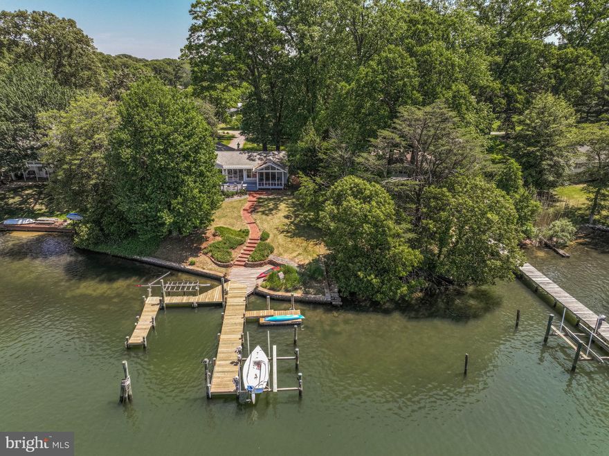 Waterfront Dream Home on Grays Creek – Boater's Paradise Awaits

Discover the ultimate waterfront lifestyle in this stunning single-level home perfectly situated on
protected Grays Creek with quick, easy access to the Chesapeake Bay. With an extra-wide 103
feet of water frontage and 6 feet MLW, this property is a boater's dream come true.

The multi-slip pier — featuring new decking (2026), 50-amp power, a 10,000 lb. Magnum boat
lift, and a floating dock ideal for kayaks and SUPs — offers everything you need to embrace life
on the water. The property’s location outside FEMA flood zones saves you worry and insurance
costs.

Step inside and enjoy an open-concept kitchen, dining, and living area bathed in natural light
from windows and sliding doors spanning the entire water-facing side of the home. The gourmet
kitchen is a chef's delight, boasting granite countertops, a 6-burner gas range, Sub-Zero
refrigerator, large pantry with pull-out sliders, and an expansive island with a second sink.
Hardwood floors flow throughout the main level, complemented by a screened porch and a fully
rebuilt deck (2024) — perfect for entertaining or simply soaking in the views.

The spacious primary suite is a true retreat, offering panoramic water views, a cozy fireplace,
walk-in closet, and a beautifully updated bathroom with heated floors. Two additional bedrooms
and an updated guest bath with heated floor complete the main level, along with a convenient
laundry area and plentiful storage throughout.

The finished lower level provides generous flexible space for hobbies, a home gym, or storage.
Practical upgrades abound: a new heat pump (Dec 2025), a two-car attached garage with an EV
charger, unfinished attic storage above the garage, and a wired shed on a concrete slab.

Tucked on a quiet, no-outlet road, this exceptional home offers rare privacy, top-tier amenities,
and an unbeatable location for those who love the water.