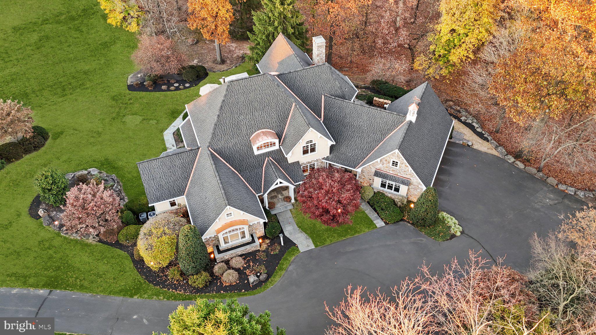 Welcome to 12 Old Cabin Rd nestled on just under 3 acres of beautiful, tree-lined property in the prestigious Upper Makefield community of Ely Farm. This home has everything you’ve been dreaming of—plenty of space, stunning design, and a location that’s close to everything while still feeling like your own private retreat. As you pull up the long driveway, the home’s curb appeal is undeniable. Brand New Roof and with high-end distinctive aesthetic with additional Copper with exceptional durability and ability to develop a natural patina overtime. The stone exterior, tapered columns, and meticulous landscaping make it feel warm and inviting, yet grand. Step through the front door, and you’re greeted by soaring vaulted ceilings, inlaid hardwood floors, and thoughtful architectural touches like custom millwork and art niches. The main living area is bathed in natural light, thanks to floor-to-ceiling windows that frame the gorgeous backyard. Imagine cozy evenings by the massive wood-burning fireplace or hosting friends in a space that flows effortlessly into the kitchen. The kitchen is as functional as it is beautiful, with a Sub Zero fridge, Wolf cooktop, double ovens, and a huge island topped with granite. The breakfast room is perfect for casual meals, while the formal dining room, complete with a fireplace and access to a Brazilian Walnut deck, sets the stage for elegant dinners or lively gatherings. For those who work from home, you’ll love the two private offices, each with custom built-ins and access to the outdoors. When it’s time to unwind, the main-level primary suite feels like your own private oasis. Vaulted ceilings, a fireplace, and cozy window seats make it a space you’ll never want to leave. And let’s not forget the spa-like bathroom, complete with heated floors, a soaking tub, a walk-in shower, and two custom walk-in closets. Upstairs, you’ll find three more en-suite bedrooms and a cozy sitting area—plenty of room for family and guests. The fully finished, walk-out lower level is an entertainer’s dream, with heated floors, a media area, a kitchenette, and even a fitness room. There’s also a fifth bedroom and full bath, making it ideal for in-laws or extended stays. Outside, the backyard is a slice of paradise. There’s plenty of space to play, a fire pit for evening hangouts, and direct access to the Ely Farm walking trail. Whether you’re enjoying the peaceful surroundings or heading out to nearby spots like Washington Crossing, New Hope, or the Delaware River, you’ll love this home’s perfect blend of tranquility and convenience. With extras like a 3-car heated garage, an electric car charging station, a partial home generator, and updated smart home features, this property truly has it all. 12 Old Cabin Rd isn’t just a house; it’s a place where memories are made. Come see it for yourself and get ready to fall in love!