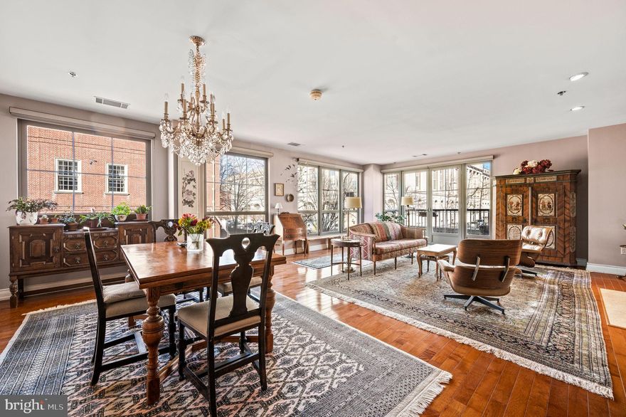 Experience an unparalleled blend of elegance and space in this exquisite three-bedroom plus den residence, boasting an expansive 80-foot terrace and dedicated parking in the prestigious Moravian. Encompassing 2,851 square feet, this refined home seamlessly merges modern luxury with timeless sophistication, set in the heart of historic Society Hill. A grand central foyer makes a striking first impression, adorned with floor stone tile. The open-concept living and dining area is bathed in natural light from wraparound windows, offering breathtaking west and north-facing views. A gas fireplace with a stone surround anchors the space, creating a warm and inviting ambiance, while rich hardwood floors extend throughout, adding to the home’s refined aesthetic. Step onto the private balcony overlooking Welcome Park—accessible from the living area, primary suite, and second bedroom—for a seamless indoor-outdoor experience.The gourmet eat-in kitchen is both beautifully appointed and highly functional, featuring a Wolf five-burner gas cooktop, GE Profile wall oven and convection microwave, Bosch dishwasher, and Samsung stainless steel refrigerator. Custom floor-to-ceiling cabinetry offers ample storage, including two lazy susans and a large pantry closet. A spacious island with a built-in wine cooler and deep storage drawers makes this space ideal for both casual dining and entertaining. Enjoy your morning coffee while taking in the cityscape from the oversized kitchen window. Beyond the main living area, a hallway leads to a versatile third bedroom, currently serving as a den, enclosed by elegant French doors. The generously sized second bedroom enjoys private balcony access, while a full hall bath and a separate laundry room—complete with large-capacity side-by-side washer and dryer—add to the home’s exceptional convenience.The serene primary suite is a private retreat, featuring floor-to-ceiling windows, cherry hardwood floors, and direct terrace access. The spa-inspired en-suite bath is a sanctuary of luxury, offering an oversized walk-in shower with state-of-the-art showerheads, a soaking tub, double sinks, and a private commode room with a linen closet. A custom-designed, expansive walk-in closet ensures effortless organization.Two adjacent bonus rooms provide endless possibilities—whether as a den, library, home office, fitness area, or private sitting room. Additional highlights include a dedicated parking space (#12) and an exceptionally large private storage unit.Situated in a boutique, full-service doorman building, The Moravian offers the perfect balance of privacy and connectivity—where historic charm meets modern convenience. Enjoy an unbeatable location just steps from acclaimed dining destinations such as Zahav and AMINA, the vibrant Headhouse Square farmers' market, and the lush greenery of Washington Square Park. Cultural landmarks, including the Ritz Landmark 5 theater and the reimagined Park at Penn’s Landing, are within easy reach. Seamless access to major transit routes ensures effortless commutes and convenient weekend getaways. Located within the coveted McCall School Catchment. A rare offering in one of Philadelphia’s most sought-after neighborhoods—where history, luxury, and modern living converge.