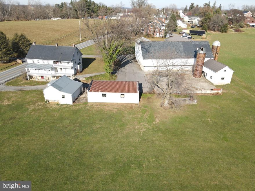 This property will be offered at Public Auction on Saturday, March 8, 2025 @ 12pm.  The listing price is the opening bid only and in no way reflects the final sale price.  10% down due at auction, 2% transfer tax to be paid by the purchaser, real estate taxes prorated. This scenic farm, located in the heart of Lancaster County, offers a prime location with nearly all tillable acreage. The property includes a two-story farmhouse, a large bank barn with three barn doors, a 4 bay concrete garage, a spring house with a garage door and workshop, and a two-story animal barn with three separate stalls. The farm features road frontage on multiple streets, a right of way, and easy access to Routes 741 and 324. Inside, the first floor of the 1812 farmhouse features a living room, an open space containing both a kitchen and dining room, perfect for entertaining, a powder room, a laundry space, and two bedrooms, one with a fireplace. Both the kitchen and living room offer stairs to the second floor which hosts five bedrooms, an office space with stairs to the attic, along with a full bathroom. The home also includes a large unfinished basement with a cold cellar, cast iron kettle cook stove, and water conditioner. The property is enrolled in the Clean & Green program, though it is not preserved. Do not miss this great opportunity in Lancaster County!