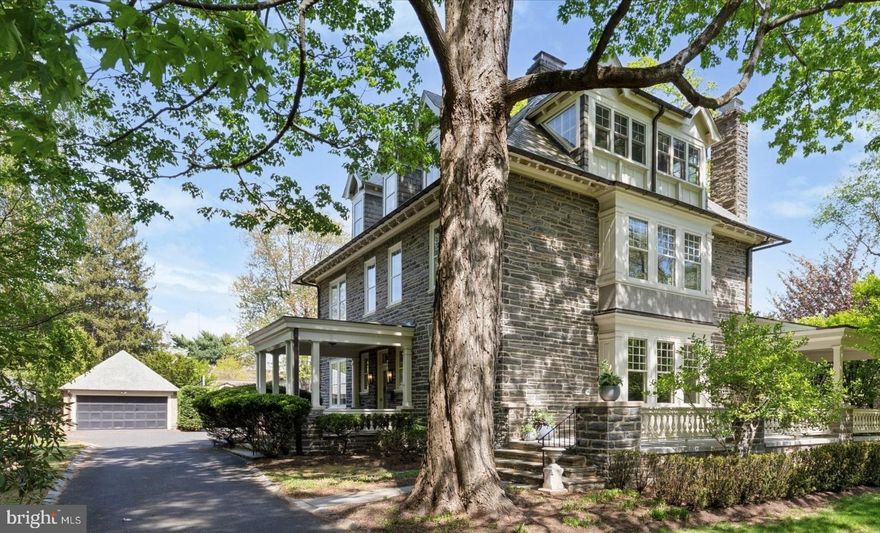 Nestled on a picturesque, tree-lined street in the sought-after neighborhood of Wyndmoor, just minutes from the shops and dining in Chestnut Hill, “Cherry Knoll” stands as one of the area's most distinguished properties. Built in 1905 for Walter Jarden, whose family has deep roots in Springfield Township, this stately Edwardian stone home exudes timeless elegance, exceptional craftsmanship and thoughtful updates for modern living.

A long, graceful driveway leads to the six bedroom, four and a half bath house built of Wissahickon shist with slate roof, copper gutters and downspouts and a stunning wraparound porch with an outdoor fireplace perfect for year-round entertaining. Step up onto the covered front porch and through the charming Dutch door into the central hall adorned with rich original woodwork, fireplace and grand center staircase. To the right, a sun-drenched living room features a cozy wood burning fireplace, built-in bookcases and benches, and French doors that open to the rear portion of the wraparound porch. To the left, a sitting room,  currently used as an office (which could be used as the dining room), offers a quiet retreat. The expansive dining room (which could be used as the family room) connects to the heart of the home: a show-stopping chef’s kitchen. Outfitted with custom cabinetry and glass display cabinetry, large center island with counter seating, Arabescato marble countertops, 6-burner Blue Star range, Thermador refrigerator and freezer, and U-Line beverage fridge, this kitchen is both beautiful and highly functional. Adjacent to the kitchen is a convenient mudroom with built-in bench, ample storage and doors accessing both the driveway and back flagstone patio. A powder room under the grand staircase completes the main floor.

Up the staircase to the second floor is a spacious landing leading to four bedrooms and three full bathrooms. The luxurious primary suite includes a dressing room, large closet, and ensuite bath with a soaking tub and separate shower. There are two additional bedrooms and a hall bathroom. Down a back hall, there is a private fourth bedroom, currently used as an exercise room, with attached bathroom that is ideal for use as an au pair suite. A convenient laundry room is also located on this level.

The third floor offers two more bedrooms, the larger one currently used as a playroom, and a hall bathroom, along with a substantial floored attic perfect for all your storage needs.

Outdoors, the lush, landscaped grounds are filled with specimen trees, mature plantings, a charming flagstone patio, a detached stone garage, and a private tennis/pickleball/sport court, ideal for active living and entertaining alike. 

Residents love Wyndmoor for its close shopping and dining venues on Willow Grove Avenue, award winning Springfield Township School District and stellar township services all while being close to the train lines, dining, and shopping in Chestnut Hill.   

This is a rare opportunity to own a legacy property that seamlessly combines historic character while being tastefully updated and maintained for today’s modern lifestyle.