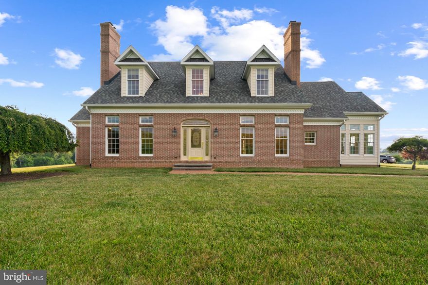 This extraordinary custom home offers breathtaking views and nearly 6,000 sqft of meticulously designed living space, nestled at the end of a long private approach and brick driveway on a sprawling 25-acre homesite. Showcasing superior craftsmanship, it features tailored finishes and luxurious details, all impeccably maintained by its original owners. Step through the front porch into an opulent interior, where elegance abounds and meticulous attention to detail is evident at every turn. The spacious grand foyer welcomes you into the open main level, leading to a formal living room with hardwood floors and a wood-burning fireplace. The sophisticated dining room, accessible through arched doorways, features a gas-burning white brick fireplace and a built-in china cabinet. A private study, accessed through French doors, boasts a stacked-stone fireplace and transom windows.  The main level also includes a well-appointed laundry room, a spacious family room with hardwood floors, a wet bar, and outdoor access, a sunroom or breakfast nook with stunning vista views, an inviting eat-in kitchen, two full bathrooms, and a luxurious primary bedroom. The chef’s kitchen boasts plentiful 42” cabinetry, some stainless steel appliances, granite countertops, a butler’s pantry complete with a pass-through window, a central island housing a gas range, and an adjacent breakfast room flooded with natural light, featuring a dedicated writing area. The lavish owner’s suite showcases hardwood floors, a spacious walk-in closet equipped with a built-in storage system, French doors opening onto the patio, and an opulent attached bathroom with three vanities, two sinks, and a luxurious soaking tub, ensuring unparalleled comfort and relaxation.  The upper-level features 2 full bathrooms, including a Jack-and-Jill setup, 3 spacious bedrooms with hardwood floors, one of which boasts a walk-in closet, and a bonus loft space perfect for crafting an extra cozy lounging area. As you descend to the lower level, you'll find luxury vinyl plank flooring that enriches a spacious recreation room, perfect for entertaining with its double-sided brick fireplace, media room, and game room. Other highlights include an 8x9 kitchen rough-in, a versatile bonus room, unfinished areas for storage or customization, a full bathroom, and a utility room.  Indulge in outdoor dining and entertaining on the stone patio, offering breathtaking views of the expansive grounds. A covered section provides added shade and comfort. The estate includes a separate 3-car pole barn, expansive croplands, a goat enclosure, and miles of sprawling countryside. Enjoy proximity to parks, dining, shopping, recreational facilities, and commuter routes such as Piney Run Park, the New Windsor Market, and access to Route 31 and Route 75.