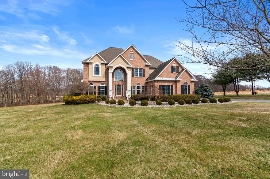 Open House Cancelled!!
Discover this stunning custom home set on a picturesque two-acre lot, offering privacy and breathtaking surroundings.  The home is tucked away from the road, accessible via a long paved driveway flanked by two stately brick entry columns.  A three-car side-load garage provides ample parking and includes an additional attached storage room.  The property backs to woods and a neighboring farm, enhancing its peaceful charm.   Step inside through the grand entrance, featuring a slate front porch, soaring two-story columns, and a striking arch top window. The dramatic two-story foyer welcomes you with a formal living room to the left and a formal dining room to the right, perfect for entertaining.  The expansive two-story family room is a showstopper, complete with custom built-ins and abundant natural light.  There is even an adjoining room one step down from the family room for additional seating or reading nook, which has vaulted ceilings and floor to ceiling stacked stone fireplace surround.  Adjacent to the family room, a versatile first-floor bedroom or office includes a full bath, offering flexibility for guests or work-from-home needs.  The gourmet kitchen is a chef’s dream, boasting a large center island, breakfast nook, pantry, and access to the rear deck.  A butler’s pantry connects the kitchen to the dining room, adding convenience, a prep sink and additional cabinets.  The entire main and upper level is solid oak hardwood flooring, except for the kitchen which is tile.   You will find special details like double crown molding, chair rail molding, recessed lighting, tray ceilings and so much more!  Upstairs, the spacious owner’s suite offers a luxurious retreat, featuring a tremendous amount of closet space with built-ins,  en-suite bath with a separate shower, jetted soaking tub, double vanity, and private water closet. The upper level also includes three additional bedrooms, two full baths and laundry room.  The fully finished lower level provides lots of living options.  It features a large family room, separate bedroom, full bath, exercise room, second laundry room, and mechanical room, all with durable plank flooring. Walk-out level doors lead directly to the rear yard, making this space perfect for an in-law suite, teen retreat, large home office, or creative studio.  There is a large rear deck with connected enclosed gazebo.   There is also a second gazebo further out in the rear yard.  This exceptional home is ready to impress—don’t miss out!