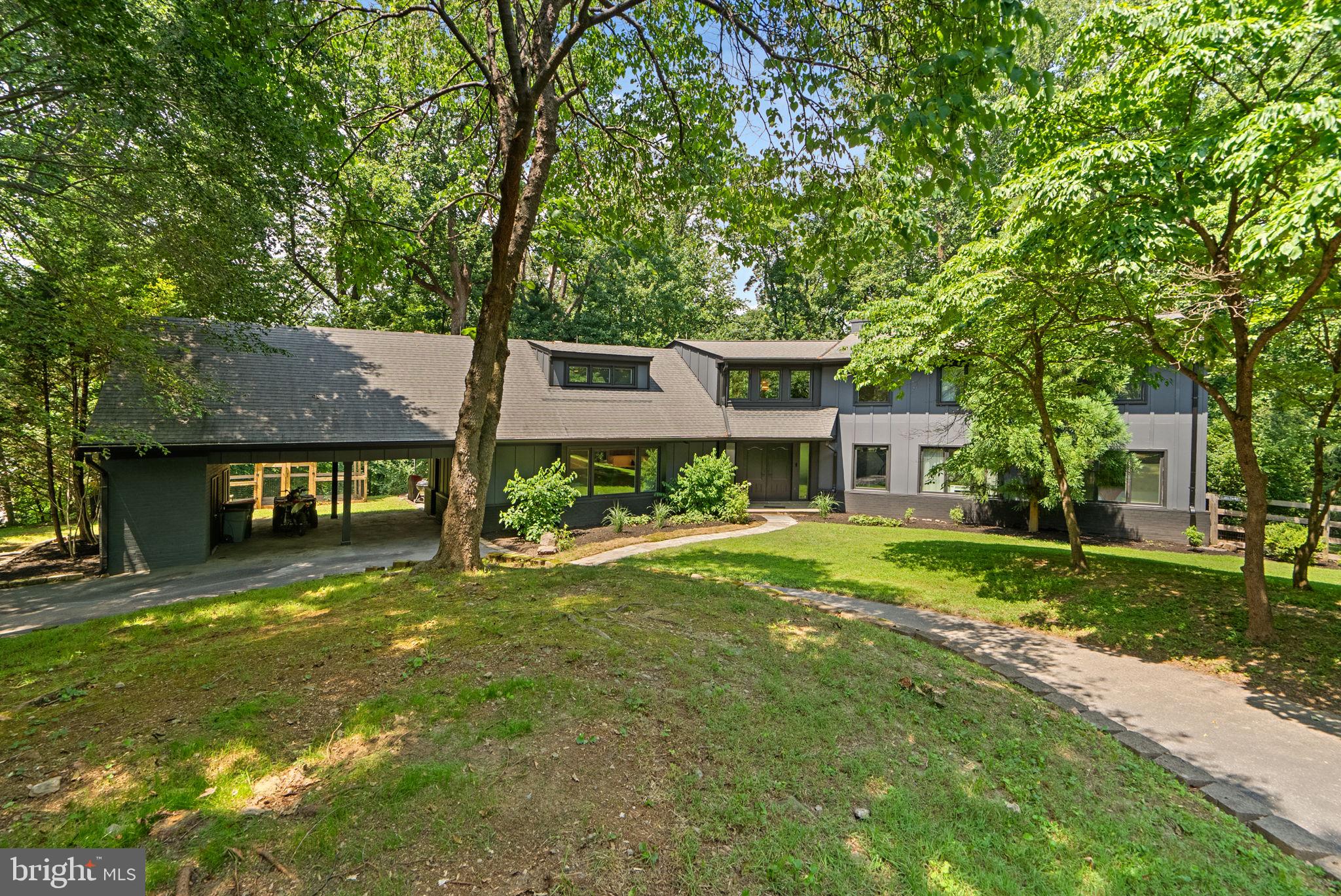 Stunning Renovated Contemporary Retreat in Prime Potomac Location! Tucked away on a private, partially fenced, wooded 2.74-acre lot in the highly desirable Potomac Manor community, this beautifully renovated contemporary residence seamlessly blends striking modern architecture with tranquil natural surroundings—just minutes from the shops and dining of Potomac Village Shopping Center.
A dramatic double-door entry opens into a soaring Great Room featuring vaulted, beamed ceilings, expansive walls of glass, and oversized windows and sliders that flood the home with natural light and invite the outdoors in. The wrap-around deck provides a spectacular setting for enjoying peaceful woodland views year-round. Anchored by a floor-to-ceiling stacked stone fireplace, the Great Room sets the tone for elegant yet relaxed living.
Completely reimagined, the gourmet kitchen is outfitted with sleek Porcelanosa cabinetry and countertops, high-end appliances, and an oversized center island perfect for entertaining. A large picture window frames the front yard, while glass sliders connect seamlessly to the screened-in porch—an ideal space for dining, relaxing, or year-round gatherings.
The main level includes a serene primary suite retreat with dual closets (including a custom walk-in), a private laundry closet, and a luxurious spa-like bath with dual vanities and a tandem shower system. A flexible additional room on the main level—with its own wood-burning fireplace—makes an excellent home office or guest bedroom.
A sweeping spiral staircase leads to the upper-level catwalk overlooking the main living space. Upstairs, you’ll find five generously sized bedrooms with picturesque views and two beautifully updated bathrooms. An unfinished space offers the opportunity for expansion or additional storage.
The walk-out lower level features a spacious recreation room with a third fireplace and a dry bar—perfect for entertaining. Glass doors open to a slate patio and a backyard fire pit area, ideal for evening gatherings. This level also includes a versatile gym room, a bedroom, and a full bath.
Additional highlights include a newly installed Hardie Plank exterior, new flooring throughout, updated HVAC and water heater systems, a main-level mudroom with powder room and laundry, a two-car carport (Seller plans to convert the carport into a 2 car garage) with storage closets, and a circular driveway with ample guest parking.
This exceptional home offers a rare combination of modern design, privacy, and convenience—just a short drive to Potomac Village, top-rated schools, and commuter routes.