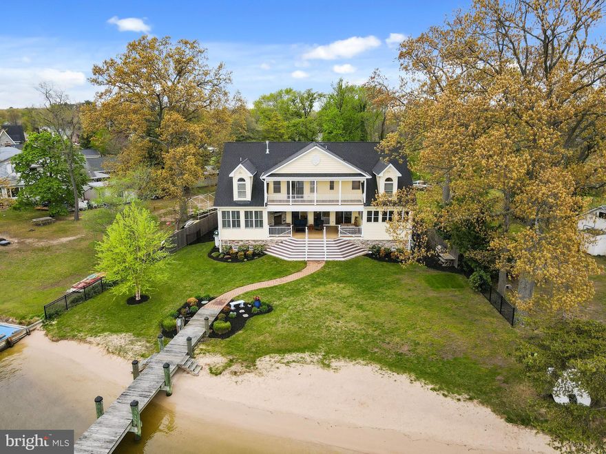 Significant Price Adjustment!  Breathtaking Views of the Bodkin from Nearly Every Room; Over 100 feet of Gorgeous Private Sandy Beach; Amazing 160 ft Pier Featuring a 15,000 lb Boat Lift, 2 Jet Ski Lifts, & a Deep Water Slip that can accommodate a 75+ Foot Yacht - This is truly Waterfront Living at its Best!  From the moment you enter the front door, the views of the Water are Striking.  Wide Open Floorplan with Floor-to-Ceiling Windows leads out to a phenomenal Covered Patio, Flat Grass Yard, and Sandy Beach and Pier just steps away, making this an Entertainer's Paradise!   Enjoy the Sunrise or Sunset View from the Great Room, sitting by the Gas Fireplace, or step out onto the Covered Patio, with its Flat-Screen TV over its own Gas Fireplace as well as Built-in Shades & Ceiling Fans for those warm summer days.   Hickory Hardwood Floors flow throughout the main level, from the Gourmet Water-View Kitchen, to the open Dining and Living Spaces, and the Water Front Office and 3rd Bedroom, both with En Suite Baths and Walk-in Closets.  Upstairs you'll find the Luxurious Primary Suite, w/Hardwood Floors, 2 Walk-in Closets,  Spacious Bath and Full-Length Balcony with Sweeping Views.  This level also features a 2nd Level Family Room and the Oversized 2nd Bedroom, also with Walk-in Closet and En Suite Bath.  Even the Attic Space, Floored and perfect for Storage, has its own Waterview!  Oversized 2-car Garage and huge crawl space gives this home more than enough storage space.