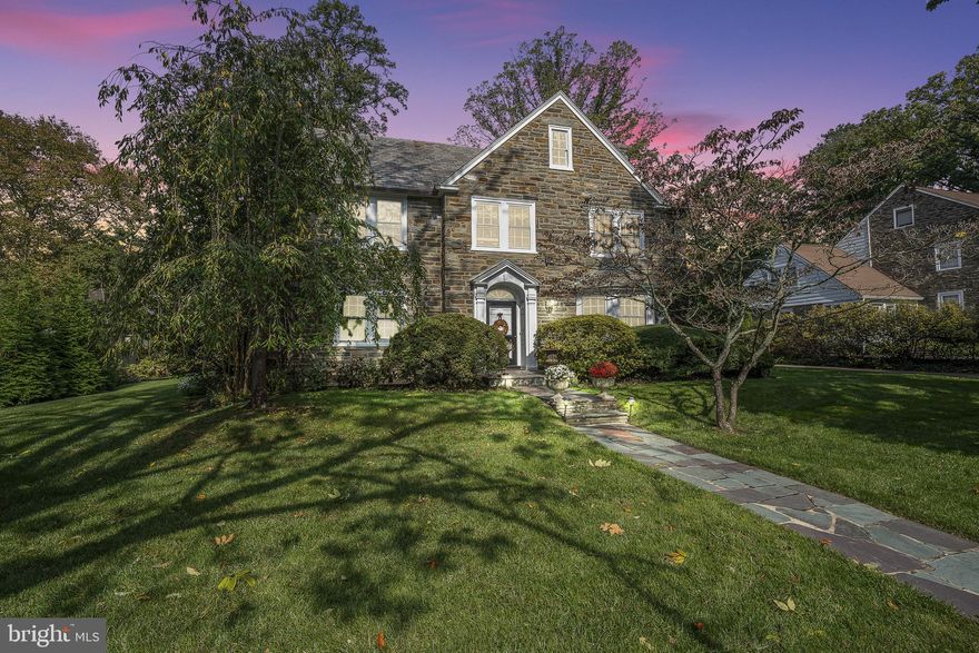 This classic center foyer stone colonial, constructed in 1933 and nestled in the sought-after Northside Haverford neighborhood, exudes enduring charm and elegance. Topped with a varied color slate roof, it carries an air of sophistication that stands strong over time.
As you step inside, you'll find handsome hand-pegged floors that flow seamlessly through the formal areas. The living room is generously bathed in natural light from three different directions, and French doors invite you to the peaceful blue stone terrace. A fireplace with a marble surround and wooden mantle provides a cozy centerpiece.
The dining room, with its chair rail and bay window, creates a welcoming space for large or intimate meals. The updated kitchen is a culinary haven, featuring a ceramic farm sink, Subzero refrigeration, and a practical 6-burner gas range with a griddle and. Added convenience comes in the form of a powder room, mudroom, and a discreetly tucked-away office space, all conveniently connected to the garage.
Climb the graceful staircase to the second level, where you'll find all five bedrooms. The primary suite is a personal retreat, boasting an ensuite bath, a fireplace, abundant southwestern sunlight, and three roomy reach-in closets. An adjacent bedroom, originally intended as a nursery but now an office, offers flexibility and potential expansion for the primary suite.
The third bedroom enjoys its own private bath with a tub/shower combination and a closet. Continue down the hall, passing a handy laundry shoot and double linen closet, and you'll discover an attractive second-level den featuring rich wood paneling, hardwood floors, a vaulted ceiling with overhead wood beams, and a stone-clad corner fireplace—a comfortable space for gatherings or work.
Completing this level are two more bedrooms and two additional baths, along with a convenient back staircase for ease of movement.
The lower level reveals a haven for recreation, with bead board paneling, built-in desks, another fireplace, and ample shelving. It also houses the home's laundry and storage facilities.
Outside, the property is fully fenced and boasts a charming front yard with a delightful tree swing, creating the perfect spot for outdoor enjoyment.
The location is unbeatable, with a short walk to the delightful shopping and dining options of Haverford Square. The nearby R5 train station provides easy access to the city. Nature enthusiasts will appreciate the bird sanctuary nearby, and the expanded neighborhood encourages exploration and a sense of community.
In essence, this classic colonial residence embodies timeless grace, modern living, and an unmatched sense of home—a gem of Northside Haverford.