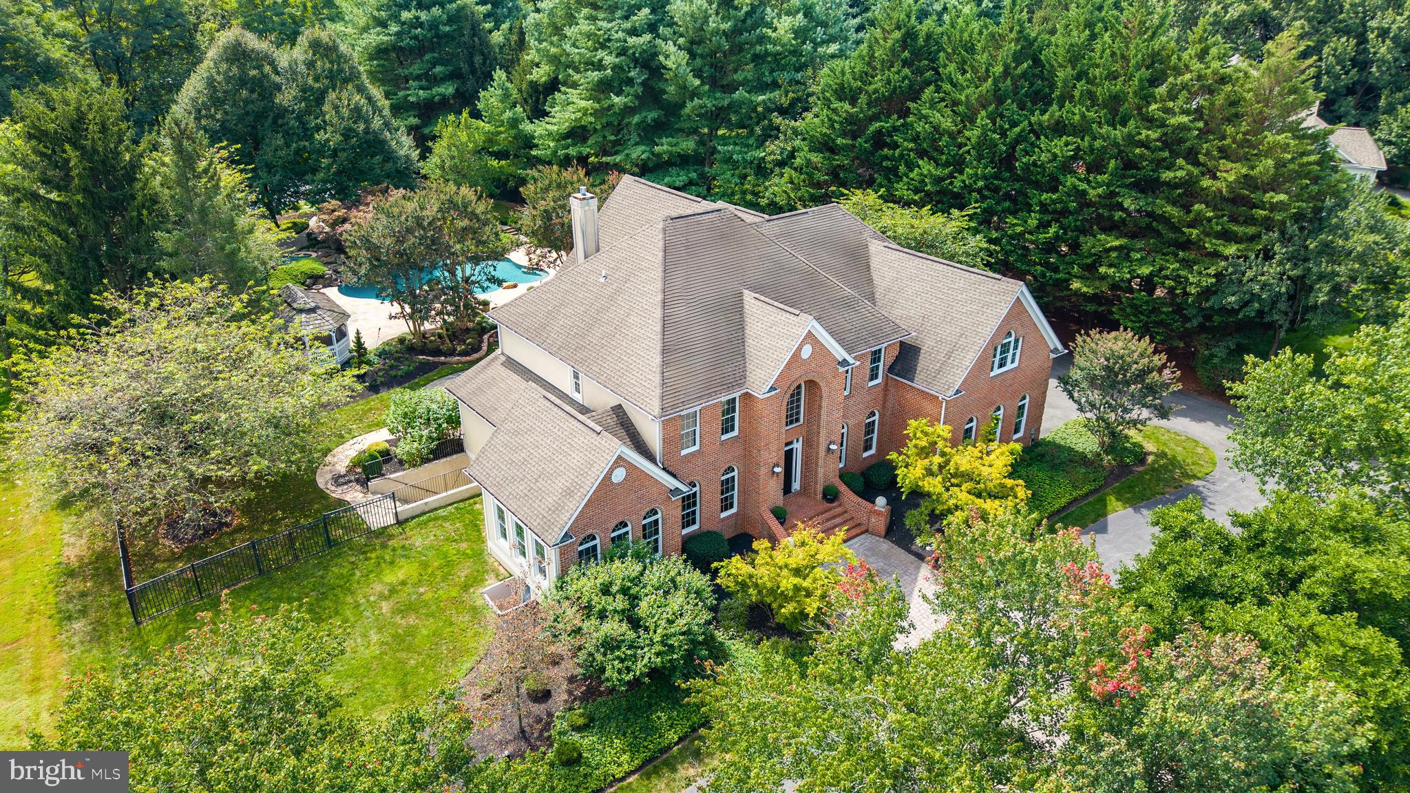 Welcome to this elegant retreat nestled in the town of West Friendship in Western Howard County. Perfectly situated off Route 32 in the beautiful Fox Valley community, this property combines timeless sophistication with modern comfort. Inside the grand two-story foyer, a sweeping staircase sets the tone for the home’s refined character. Graceful sitting rooms with soaring cathedral ceilings, chandeliers, crown molding, and warm hardwood floors invite both comfortable everyday living and entertaining. The family room is the heart of the home, and has new carpeting, stunning custom built-in cabinets, floor-to-ceiling windows, and a cozy gas fireplace. The open kitchen features a large kitchen island with a prep sink, great cabinet space, wall ovens, and spacious walk-in pantry. The main level has an ideal layout, offering a half bath as well as a full bedroom with a private ensuite that opens directly to the patio - ideal for guests or multi-generational living. Upstairs, three additional bedrooms share a well-appointed full bath, while the primary suite provides a serene space. Enjoy a lovely private sitting area with pocket doors, walk-in closets, and a spa-like en suite bath with double sinks and a spa tub. The unfinished walkout basement provides endless potential with a rough-in for an additional bath, allowing you to customize the space to your lifestyle. Outdoors, the property transforms into a private resort. An expansive patio and professionally landscaped grounds lead to a sparkling pool with waterfall features, spa, and tranquil pond. A charming gazebo with electricity offers the perfect spot for shaded gatherings, while the paved court adds versatility for outdoor sports. Additional highlights include a two-car garage, dual-zone air conditioning, and the ideal location within Western Howard County’s rolling landscapes.