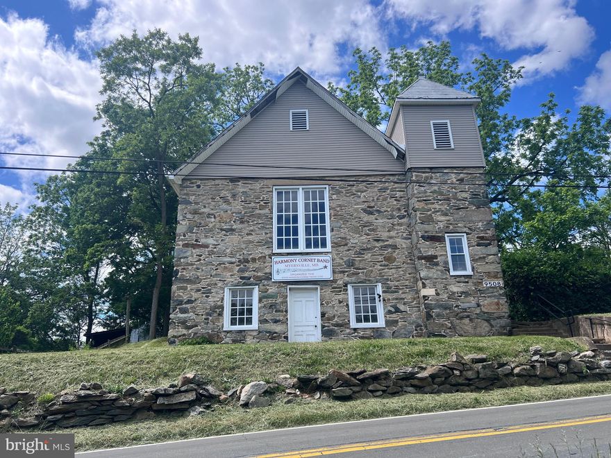 Nestled within the picturesque landscapes of Myersville, Maryland, 9508 Harmony Rd stands as a charming testament to history and possibility. This stone structure has been the heart and soul of the Harmony Cornet Band for over 75 years. This property offers many possibilities for your hobby, professional or personal use. The absence of a well (NO POTABLE WATER) or septic system (NO BATHROOM / NO KITCHEN) invites imaginative solutions to complement its rustic charm.  The property is zoned R1 Residential and has grandfathered commercial use as a band hall for The Harmony Cornet Band.  Buyer to verify permissible uses.