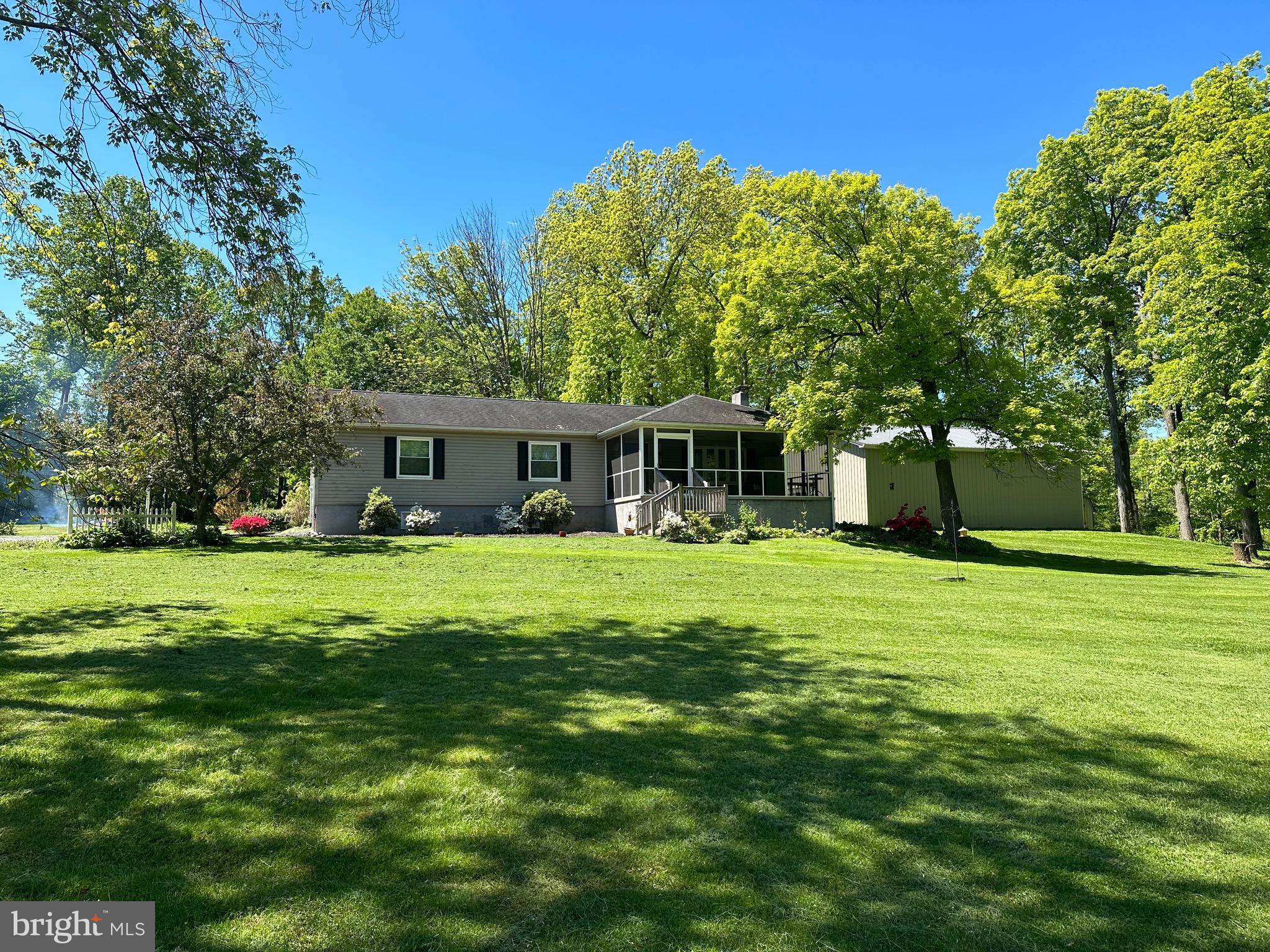 Welcome to this updated, well-maintained 3BR, 3 full bath, 2 kitchen Rancher set back from the road amidst 9.5 acres of lush lawn and woods. This property is perfect for the outdoors-lovers! Hike the woods, follow the spring-water creek, pick berries along the tree-line. The screened front porch is the perfect place to sit with your morning coffee and watch deer play and turkeys walk the lawn. There is a lower level rec room w/ gas fireplace, second kitchen and additional 4th bedroom- perfect for guests or in-laws, and includes a utility room/workshop and a full bath (Saniflo system).  The main floor includes a four-season room with deck access to the hot tub to end your day. New air conditioning system. Newer flooring. New oversized 3 car garage - with one extra tall bay door and 6in concrete flooring in that bay that could accommodate a lift . Oversized shed. Additional parking lot. Many updates throughout!