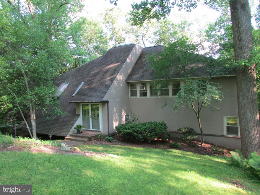 Situated down a private lane, this custom home is surrounded by nature with expansive green vistas overlooking Fairmount Park. This exceptional property was originally part of the adjacent Krisheim Estate, home to the Houston family: the original planners and developers of Chestnut Hill. It is truly a magical setting with unmatched privacy and serenity yet a short walk to Chestnut Hill's wonderful shops and restaurants and easy access to Center City. This contemporary gem offers sweeping open spaces, soaring vaulted ceilings and light filled rooms all oriented to bring the outdoors in. The step down living room with fireplace opens to a cozy family room with charming wood burning stove. The kitchen area includes an open bar, built in desk, center island and space for a large kitchen table next to a wall of sliding glass doors that lead to an elevated deck overlooking the treetops. Dining room, powder room and laundry room complete the first floor. The second floor includes the master suite and three additional bedrooms and a hall bath. The master suite includes a large en suite bath, many closets, its own private deck and stairs that lead to a charming loft/office area. Two of the hall bedrooms include loft areas, as well. At the end of your hectic day, open the door and escape to your own private retreat.