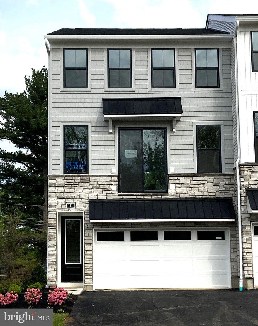 This end-unit home is currently under construction and showcases a thoughtfully designed layout with elegant finishes throughout. The entry level features a welcoming foyer that leads to a versatile flex room ideal for a home office or lounge, a convenient powder room, and a drop zone off the garage entry. Access from the garage into the flex area and everyday entry provides organization and ease.

On the second floor, the open-concept main living level includes a spacious great room and a bright casual dining area, both with close proximity to the kitchen. The beautifully appointed kitchen offers white cabinetry, quartz countertops, an upgraded tile backsplash, under-cabinet lighting, and KitchenAid appliances. Engineered hardwood flooring extends throughout the main living areas, complemented by recessed lighting that enhances the home’s warm, inviting atmosphere. A deck off the great room provides additional space for outdoor enjoyment.

Upstairs, the luxurious primary suite includes dual walk-in closets and a spa-inspired bath with quartz countertops, upgraded tile, and a frameless glass shower enclosure. Two secondary bedrooms share a full hall bath with designer tile. Additional highlights include bedroom-level laundry and carefully selected finishes that balance modern style with everyday comfort.