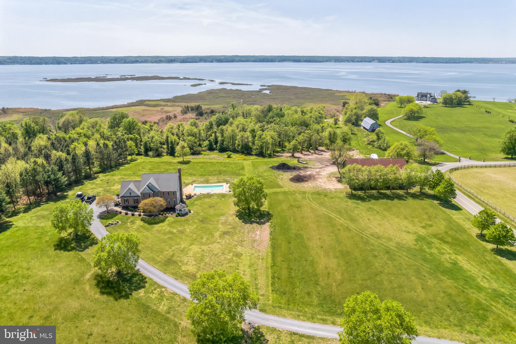 SWEET SERENITY IN SOUTHERN MARYLAND! IMMACULATE 21+ ACRE Calvert County GEM! Unbelievable WATERFRONT property with POOL, HISTORIC BARN, IN-LAW APARTMENT and PRIVATE BEACH - Welcome to 5100 Williams Wharf Road, St. Leonard, MD. THIS PROPERTY IS A HUNTER AND FISHERMAN's PARADISE with approximately 500 feet of water frontage, duck blind, multiple deer feeders, tree stands, cleared land, wooded land and beachfront, as well as acres upon acres to hunt, fish, entertain and enjoy! Follow the river birch tree-lined private drive to this beautiful estate. The home itself is a timeless treasure, a custom built 3-story colonial with 5 bedrooms, 4 bathrooms, 2 laundry rooms, fully finished basement with in-law apartment, home office, gourmet kitchen and high-end interior finishes throughout. Enter the foyer where you are greeted by a grand staircase and gleaming hardwood floors that carry through the main living area on the first floor. To the left is the dining room to enjoy formal or family meals at every occasion. To the right is the spacious living room with impressive built in bookcases. The living room makes way to the incredible family room with soaring 2-story ceiling height, a stone to ceiling wood burning fireplace and 2-story wall of windows that fill the room with gorgeous, natural light. The family room lets out to the expansive back deck with steps to grade, for a incomparable view of the scenic property and the breathtaking Patuxent River sunset.
Back inside and open to the family room, is the gourmet kitchen and beautiful bay window kitchen nook. The kitchen is bright and airy with plenty of cabinet space, a center island and shining stainless steel appliances including a 5-burner cooktop, french door refrigerator and double wall ovens. The hallway and butlers pantry area leads to an oversized 2+ car garage with a service door for easy access to the exterior. On the upper level of the home you will find 4 large bedrooms, to include a large home office/recreation room with custom built bar. The owner's suite is grand and includes an enormous walk-in closet and private bathroom with dual vanity sinks and separate tub and stand-up shower. Enjoy views of the changing seasons from the upper hall palladian window.
The lower level of the home is it's own private entity! With private, direct exterior access to the backyard and pool, it's own separate laundry room, a quaint and charming kitchenette with peninsula, a large and welcoming family room, an in-law suite with plentiful closet space and attached bathroom. The in-law bathroom includes a jetted soaking tub, stand up shower and dual vanity sinks. There is also a separate office/den in the lower level that is currently being used as a 6th bedroom.
The amenities at this property are endless! A beautifully landscaped lead way brings you to the sports pool, which is heated, in-ground and includes an auto cover. All pool equipment will covey with the home sale. To the right of the pool, on the rolling hilltop is an incredible historic tobacco barn with main center beams which date back to the Civil War Era. The property is a unique and rare mix of cleared land to farm, wooded land to hunt and beachfront to access Battle Creek and the coveted Patuxent River. 5100 Williams Wharf Road is a rare and astounding treasure - there is no property quite like it in Southern Maryland! Schedule your private tour today!