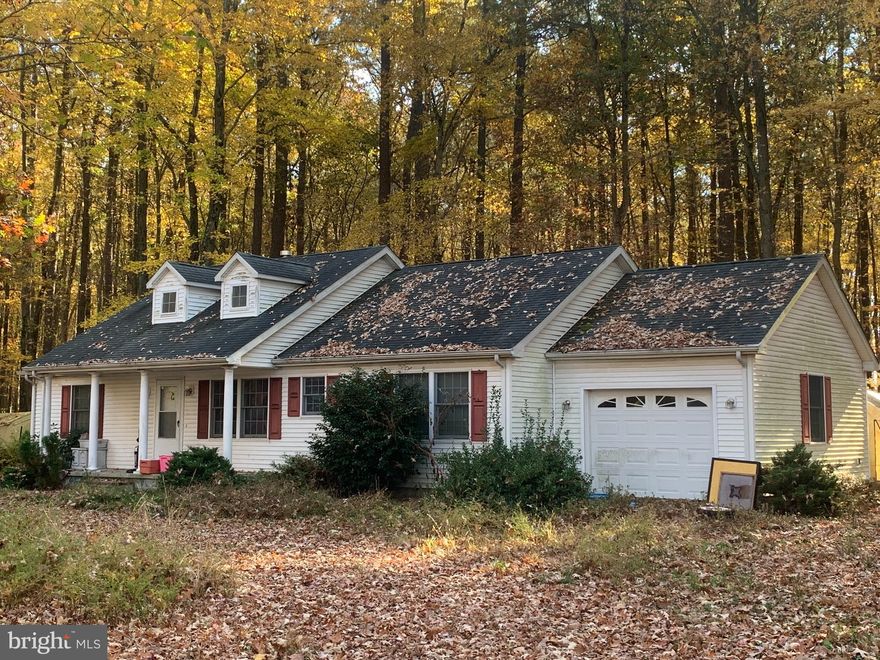 Nice peaceful wooded property with public water & sewer. Built in 2009, this 3BR/2 bath house is in need of renovations and repairs.  The approximate 8 acre parcel of land  may be subdivided into 2 or more building lots, according to the Seller.  Please check with the County for confirmation.  Also,  at least one more water/sewer allocation may be purchased from the County.   Again,  please check with the County for confirmation.