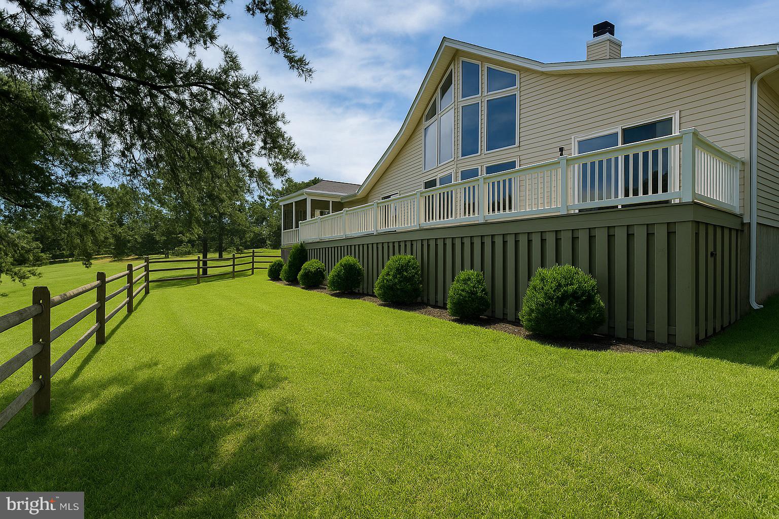 This newly designer-updated home sits on the 6th fairway of the Mountain View Golf Course, tucked away on Wampum Lane—a quiet street lined with large, lovely homes adjoining the course. At the center of the home is a striking three-sided, wood-burning natural stone fireplace with a raised hearth that rises to meet exposed wood beams of the cathedral ceiling. This dramatic architectural feature is rivaled only by the wall of windows that brings in sweeping views of the rolling green fairway, a stunning visual that beautifully contrasts with the interior’s warm palette of pale yellow tones and modern black accents. The home includes three bedrooms, two bathrooms, a spacious open loft, and a detached two-car garage with storage. With its vaulted ceilings and open design, the home has a bright and expansive feel that’s both inviting and stylish. It’s perfect for entertaining, with a modern kitchen that flows into the dining and living areas, as well as out onto the large rear deck and a comfortable screened-in porch. The kitchen features Yorktown maple cabinetry, Corian countertops, and under-cabinet lighting. The interior and exterior have been freshly painted, and designer lighting fixtures were recently installed throughout. Both bathrooms have new faucets and trim. Hardwood flooring runs through the main living areas, tile accents the kitchen, and plush carpet adds warmth in the bedrooms and loft. Outside, the home’s paved driveway is bordered by extensive hardscaping for low-maintenance curb appeal. Recent improvements include a brand new grinder pump and a new 50-gallon water heater, both installed following a completed seller’s home inspection. A rendering shows a potential split-rail fence layout to help buyers visualize the large side and rear yard, and this fence type is permitted by the HOA. The property also qualifies for a Woods Club Membership, offering access to indoor and outdoor pools, tennis, golf, spa services, and more. Whether you’re looking for a full-time residence or a luxury golf-course retreat, 477 Wampum Lane offers turnkey living in one of the most desirable pockets of The Woods. All design and staging by Honey House. All documentation is available.