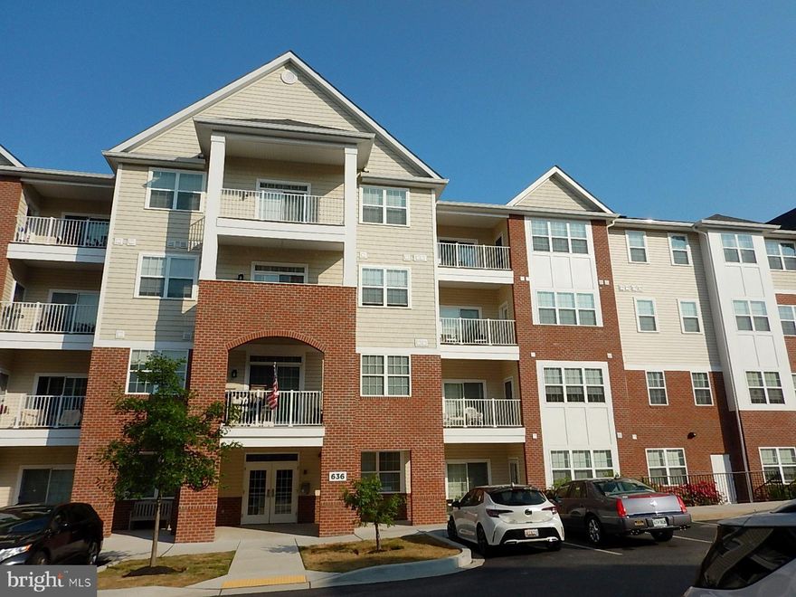 Immaculate "Like New" home, 100% ready for a new homeowner. This 55+ community backs directly to the Ma and Pa Trail, with 2 access paths. Pull into the attached garage (auto-opener), use one of your 2 assigned parking spaces (68 & 68A), then take the elevator to the 4th floor to your beautiful home. This is the "Penthouse" level or top floor. There is a wonderful balcony that can be accessed from both the living room and the primary bedroom. Spacious walk-in closet and owner's bath. The home has 9-foot ceilings, recessed lighting, and luxury vinyl plank flooring. Gorgeous kitchen features upgraded stainless steel appliances, plenty of cabinet space, and a pantry. There is a small common storage area in the hallway. The mailroom is on the first floor of the secure building. Residents have access to the exercise room and community center/party room. Two pets are allowed in the condo, including dogs. Included and paid for by the seller is a 1-year Home Warranty that covers all appliances, HVAC systems, plumbing, electric, and more. Excellent opportunity!