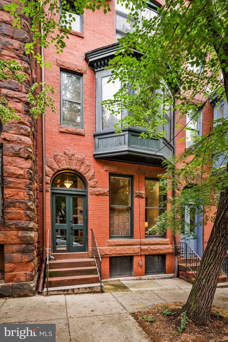 You know what you're looking for. You've lived in Brooklyn, or Capitol Hill, or Fishtown, or you grew up in a house with real bones and real history and you've spent years trying to find that feeling again. You care about original details, authentic neighborhoods, and neighbors who actually know your name. You are done with the flips, the gray paint, and the LVP flooring. You want the real thing. This is the real thing.

Tucked on a quiet, tree-lined corner in the coveted Mount Royal Terrace section of Reservoir Hill, this Victorian has been thoughtfully restored and genuinely loved. First by the writers, artists, and bohemians who have passed through its doors since the 19th century, most recently by its current owners, both professors, writers, and artists themselves. Among its most celebrated former residents was Carleton Jones, a beloved Sunday Sun writer and author of Streetwise Baltimore, who captured the soul of this city from within these very walls. That lineage of creative, intellectual life is not incidental to this house. It is baked into it.

Step inside and you will feel it immediately. Heart pine floors that have stood the test of time, majestic  original windows, fresh paint where it was needed and original detail preserved everywhere it wasn't. Three stunning mantels with intricate original tilework. Moldings that were never ripped out and replaced with nothing. This is a home where every decision, across multiple generations of ownership, was made with care and with taste.

The main level sets the tone beautifully. A gracious living room anchored by an original mantel flows into a formal dining room dressed in a rich, sultry color scheme that feels both historic and deeply current. The first floor half bath is thoughtfully placed, and the kitchen is exactly what a house like this deserves, well conceived, with ample cabinetry, generous prep space, and the extraordinary bonus of the original brick kitchen hearth still intact. Step out from the kitchen onto the private rear deck and you're looking out over a pocket park, your own quiet green view in the middle of the city.

Upstairs, the second floor offers three bedrooms and a charming, recently updated full bath, each room having found its own life over the years. A welcoming front room used as both family room and home office, a cozy middle room that served as a nursery, and a rear bedroom that has been a guest room, a study, and everything in between. The flexibility here is real.

The third floor is where this house saves its best surprise. A generous owner's suite with a refreshed vintage bathroom and a dedicated dressing room or office space. It is private, quiet, and flooded with light. It is the kind of retreat that makes working from home not just possible but genuinely pleasurable.

The current owners have also invested wisely in the home's future. The flat roof was just inspected and refreshed in May 2026 and comes with a one year certification, while the street-facing mansard roof was rebuilt and retiled with slate in 2022The soaring, custom front third-floor windows were built to Maryland Historic Trust  specifications, fitted with custom trim and medallions, and flashed with copper. The exterior was fully repainted to period standard in 2022 in Rookwood Shutter Green. The rear bay sleeping porch was restored inside and out, and re-insulated. The second floor front bay window was restored and fitted with custom Baltimore Bullnose trim. A brand-new hot water heater, fresh paint, gleaming floors, robust central air conditioning, and stained glass are all here in a home that has been loved and maintained at every turn. Move in with confidence.

And then there's the neighborhood itself. Reservoir Hill—and Mt. Royal Terrace in particular—is the kind of community you didn't think existed anymore in the city. Long-time residents who chose to stay. Neighbors who know each other. A street where kids play outside and people stop to talk. A place with ge