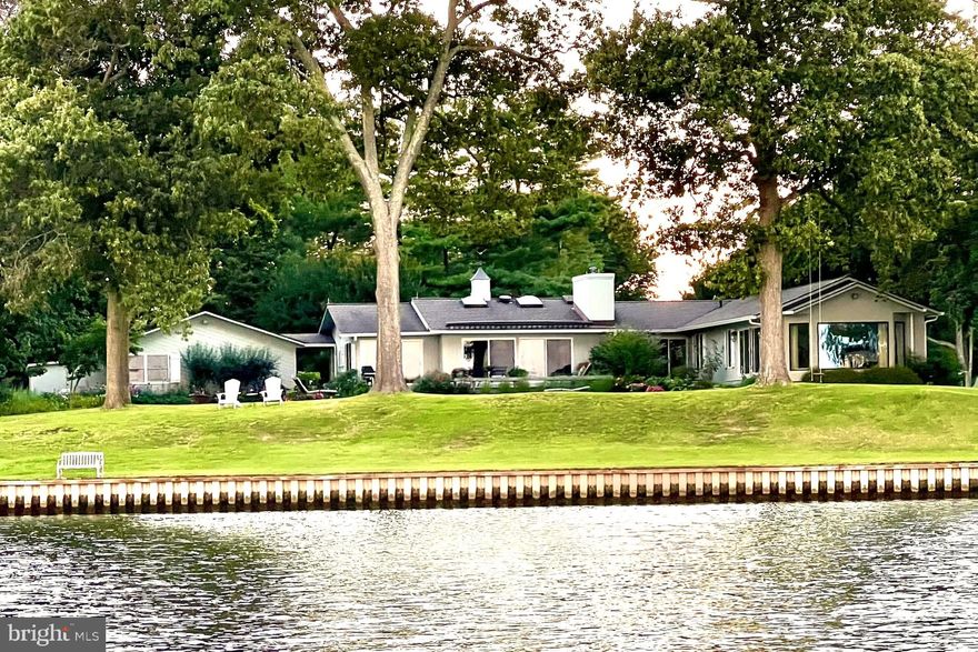 *Professional photos Coming.  Welcome to “This is Wye”! Set on a spectacular elevated lot along the Wye River, this exceptional property captures breathtaking views of both the river and Wye Island. This beautifully designed one-level residence offers 3 bedrooms and 3.5 baths, delivering effortless waterfront living with a refined, thoughtful layout. Completely renovated in 2018 and enhanced with ongoing updates through 2026, the home features hardwood flooring throughout, along with abundant windows and skylights that fill the interiors with natural light and showcase expansive water views from nearly every room.
The gourmet eat-in kitchen is both stylish and functional, equipped with top-of-the-line appliances, a generous center island, convenient mudroom, and seamless flow into the main living spaces. The living room opens naturally to the dining area and is anchored by a wood-burning stove insert, creating a warm and inviting focal point. A separate yet connected family room provides additional gathering space, and both rooms feature sliding glass doors that lead to the waterside patio, pool, and deck—ideal for indoor-outdoor living.
The primary suite is a private retreat, set in its own wing and thoughtfully appointed with dual walk-in closets and two en suite baths. One bath features a double-sink vanity, soaking tub, and glass-enclosed shower, while the second offers a single-sink vanity and glass-enclosed shower. Two additional bedrooms share a well-designed Jack-and-Jill bath, and a charming powder room completes the interior.
Outdoors, the property is equally impressive, with a waterside gunite pool, expansive decking, and approximately 450 feet of bulkheaded shoreline. The new protected pier offers 5+'MLW and includes a lift, three slips, and a floating dock, making it ideal for boating enthusiasts.
A detached, oversized garage, connected by a breezeway, includes a spacious office and workshop, while two additional storage sheds provide ample space for equipment and tools. Mature landscaping, trees, and extensive hardscaping create a private, picturesque setting.
Recent improvements include the renovated kitchen and baths, refurbished pool, Andersen windows and doors, encapsulated crawlspace, generator, and tankless water heater—offering a truly turnkey waterfront lifestyle.