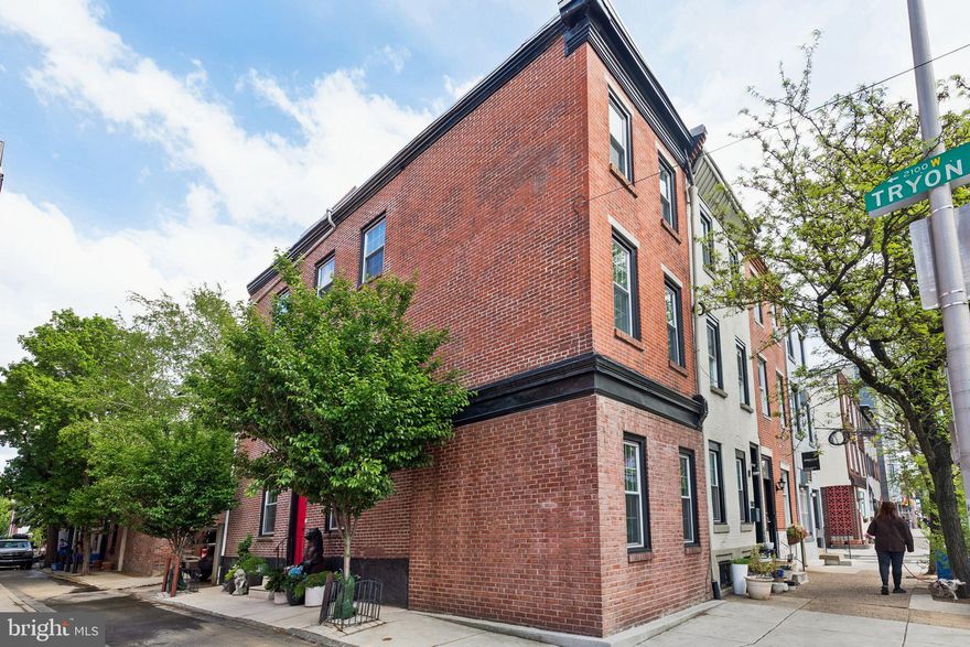 Set on a sun-drenched corner at 22nd and Tryon, this classic brick residence offers the best of Center City living at the intersection of Fitler Square and Rittenhouse. With rare pull-in parking, private roof deck, and windows on three side of the home for all three stories, the property delivers both convenience and style in one of Philadelphia’s most sought-after neighborhoods. Step inside to a welcoming entry with custom built-ins for coats and shoes. To the right, you’ll find a bright living and dining area featuring built-in cabinetry and a charming banquette, perfect for everyday dining or entertaining. A convenient powder room and access to the lower level are also located off of this space. To the left of the entry, the updated kitchen offers ample cabinetry, generous counter space, and stainless steel appliances, and opens seamlessly to your private parking space, making unloading groceries effortless. Upstairs, the second floor hosts two well-proportioned bedrooms and a beautifully updated full bath with modern finishes throughout. The entire top floor is dedicated to the primary suite featuring vaulted ceilings, windows on two exposures, 2 generous closets, and space for a sitting area or workspace. The en-suite bath offers double vanities, an oversized glass-enclosed shower, and refined tilework for a spa-like experience. Crowning the home is a roof deck with sweeping city views.The location is unmatched - just steps from Fitler Square Park, the Schuylkill River Trail, and Rittenhouse Square, with easy access to University City, 30th Street Station, and major highways via the South Street Bridge. Enjoy neighborhood favorites like Rival Bros Coffee, Rowhome, Trattoria Carina, Ambrosia, and everyday conveniences including Heirloom Market, pharmacies, and more. Located within the Greenfield School catchment. A rare opportunity to own a corner home with parking, outdoor space, and skyline views in one of Philadelphia’s most desirable neighborhoods.
