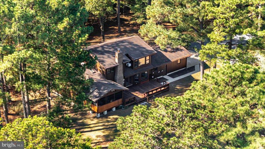 Nestled on 2.5+/- wooded acres along Broad Creek, this contemporary four-bedroom, two-and-a-half-bath Lindal Cedar Home offers stunning water views from most rooms. Relax on the expansive waterside deck or enjoy the serenity of the screened porch with skylights. Surrounded by mature trees, this private retreat is perfect for nature lovers, with frequent sightings of wildlife and birds. Inside, the first floor features a cozy family room with a brick hearth fireplace, a bright den, a kitchen with a formal dining area, and a primary en-suite that opens to the porch. Upstairs, you’ll find three additional bedrooms and a full bath. Ample storage is available with a two-car attached garage and a storage shed. Located just minutes from St. Michaels, this property also boasts a private dock with approx. 2.5+/- ft MLW —ideal for launching your boat and spending the day fishing or exploring nearby Oxford, Cambridge, or Tilghman Island for waterfront dining.   (*Buyer to verify water depth)