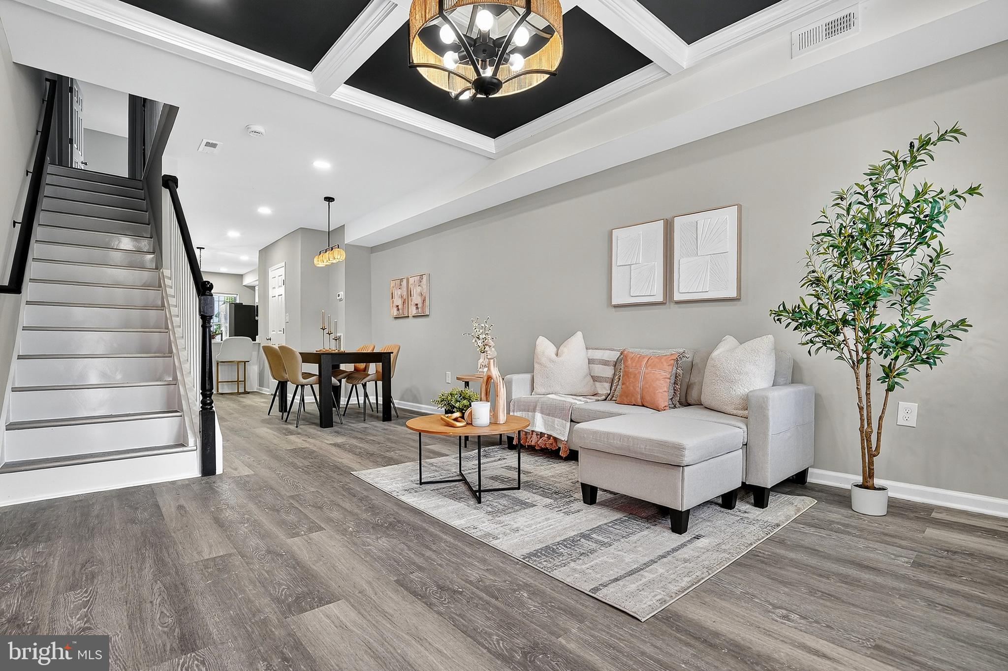 Welcome to this stunning 5-bedroom, 3-full-bathroom townhouse, where modern design meets comfortable living. The spacious main floor boasts an open-concept layout, perfect for entertaining. The living room features a striking accent wall of exposed brick, a stylish dark-blue and white coffered ceiling, and beautiful wood-style flooring that flows throughout. Natural light streams in through large windows, creating a bright and airy atmosphere. The adjacent dining area provides ample space for a large table, and is illuminated by a chic chandelier. The kitchen is a chef's dream, with pristine white cabinetry, a modern subway tile backsplash, and sleek stainless steel appliances, including a large French-door refrigerator, microwave, and dishwasher. A large center island with seating for two provides a casual dining option.
Upstairs, you'll find the bedrooms, each offering a peaceful retreat. The bedrooms are painted in a soft, neutral gray, creating a calm and serene environment. They feature plush carpeting and large windows, and are a blank canvas for your personal style. All bathrooms are true masterpieces of design, with white marble-style tiling accented by a beautiful honeycomb pattern in a metallic gold finish, and a walk-in shower with a black and white pebble-style floor. The vanity features a white countertop and a modern gold-toned faucet. A second full bathroom continues the elegant theme with a large white vanity, a mirror framed in black, and a shower with classic white subway tiles accented by a bold black stripe of mosaic tile. This beautiful townhouse is the perfect blend of style and functionality, offering a fantastic living experience for you and your family.
Schedule your showing today!