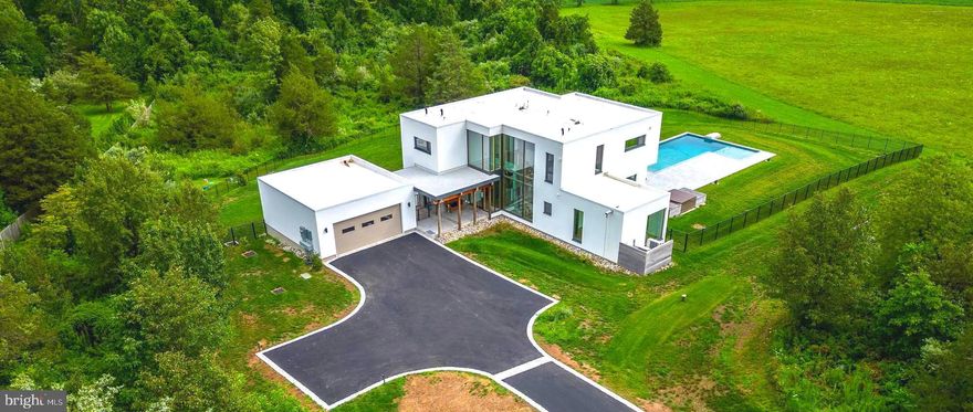 Doylestown, Bucks County Custom-Built Home with Outdoor Poolside Oasis! Picturesquely nestled on a sprawling 2.95-acre lot just minutes from shopping and restaurants, this 4BR/3.5BA offers unparalleled modern beauty with the added benefit of eco-friendly design and superb functionality. Originally built in 2020 by the forward-thinking company, ecoDOMUS, the lavishly stylish residence integrates environmentally conscious choices, while maintaining incomparable design flow. Beautifully fashioned with contemporary architectural elements, the energy-efficient home dazzles with a brand-new driveway outlined in Belgium stone, an inviting foyer, an organically flowing floorplan, luminous natural light, gorgeous wood flooring, an elegant floating staircase, and an expansive living room with a Dekton quartz paneled, double-sided fireplace (ventless bioethanol insert). Culinary enthusiasts will bask in the gourmet kitchen, which includes stainless-steel appliances, breakfast bar peninsula w/waterfall edges, European-inspired cabinets, a dining area, and an adjoining family room. Venture outdoors to discover an entertainment-ready backyard with a sparkling pool, tanning ledge, tons of room for lounging, and blissful nature views. Offering multigenerational appeal and a range of flex space possibilities, the finished walkout lower-level has a large bedroom, full bathroom, media room, office/exercise/study room, and a tranquil cedar spa/sauna. Explore the upper-level to find the primary bedroom, which impresses with abundant closet space and a luxe en suite boasting a standalone soaking tub, steam shower, and dual sinks. Two additional upper-level bedrooms are generously sized, while the full guest bathroom elevates self-care with premium finishes. Other features: 2-car garage, outdoor shower, heated salt water pool with in pool lounging area, laundry room, air filtration system, central vacuum, triple pane windows, near excellent schools (Central Bucks SD), and more! Call now for your exclusive tour!  Please note - All square footages, taxes, descriptions, etc. are to the best of agent knowledge and ability.