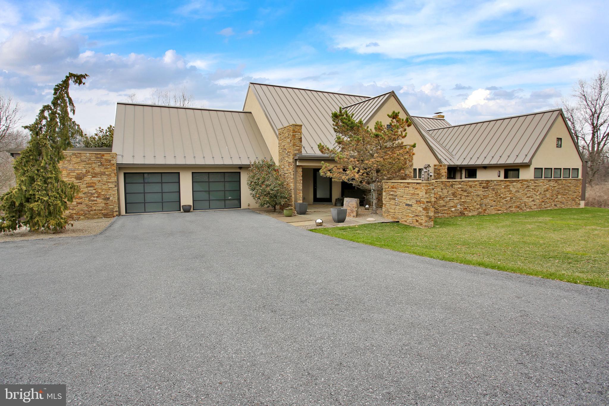 In a word, spectacular, can only begin to describe this custom dream home that was designed to inspire the feel of “Bringing Nature and the Outdoors Into the Home”. An execution of the design inspiration includes large windows to view nature, stone walls cutting thru the home, a private driveway and trees blocking the property all around as well as interior natural warm tones with reclaimed barn woods. These natural elements and privacy mixed with the clean, modern feel, make it very special and unique. You get the best of both worlds by mixing modern big city design and Oley nature together all on 30 acres. Main floor layout includes unique entry foyer, spacious living room open to kitchen with large center seated island, Walnut cabinets, walk-in pantry and dining area, primary bedroom suite with impressive custom bath and walk-in closet next to laundry area. There is also a half bath and mud room. Upper floor has a large loft area, 2 beautiful spacious additional bedrooms each with their own full bath and 2nd floor laundry room. Walkout lower level is professionally finished to provide open living room and full kitchen, 4th bedroom and full bath making it perfect for additional living area. This home is better than new built 10 years ago filled with special features and amenities including laundry on all 3 levels, all bedrooms have en-suite, 2 car attached garage with additional 3rd garage door for extra storage, detached garage, high end bath fixtures, beautiful and unique lighting fixtures, gas fireplace, multiple walk-in closets, whole house sound system, full bath with each bedroom, large picture windows everywhere for fantastic views. The solar panels, upper level heat pump, metal roof, the found object light and reclaimed wood materials were used to support a lower energy and greener living for the home. There is a complete security/fire system an UV reverse osmosis water system. Of the 30 total acres, 19 are Clean and Green. The home exterior was designed to be all you could ever want year around as a family oriented compound. The beach entry pool for summer, the fire pit for spring/fall, 3 ponds with wildlife and the side hill for sledding allows year around fun. All this provides you and your family your very own resort in your own back yard. This is a must see outdoor oasis. Be sure to view each and every photo as well as video to see all this property has to offer. This description would be endless if everything was listed. If ever there was a must see property, this is it. Call for more info.