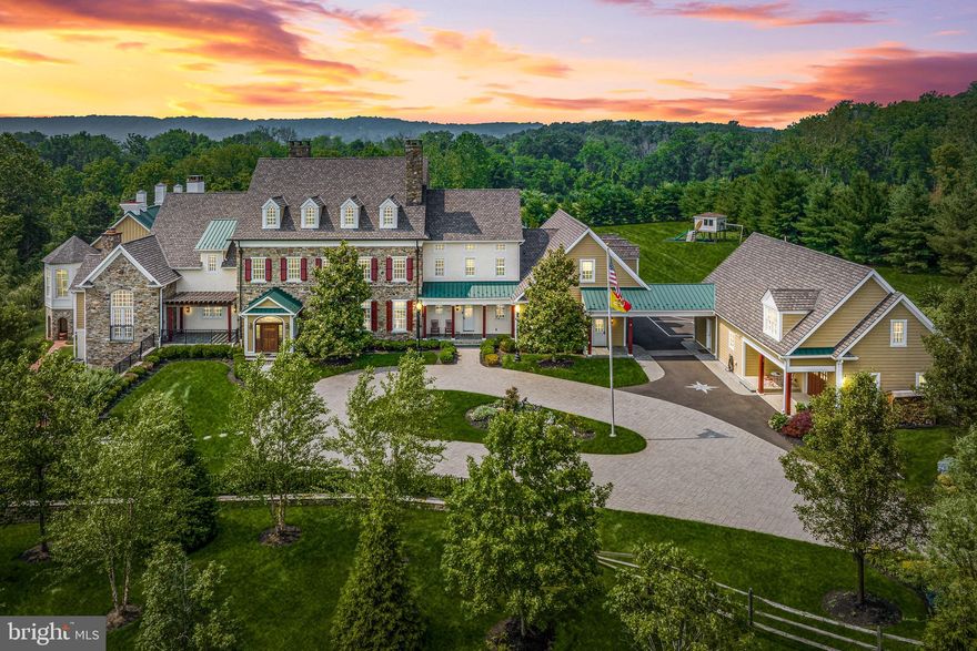 Experience the unparalleled beauty of a Bucks County Manor Home, nestled on expansive estate-like grounds.  This exquisite property offers a blend of custom craftsmanship and stunning details, making it truly one-of-a-kind. Nestled away on a tranquil country drive and gated for privacy, this elegantly appointed estate presents a myriad of desirable features: expansive acreage, a picturesque pond, an elegant pool, a separate guest house, and a thoughtfully designed main house. Prepare to be captivated by the impeccable millwork found throughout the property, showcasing intricate hand-carved details, coffered ceilings, wainscoting, and extraordinary chapel beams. Natural materials, including Bucks County fieldstone, brick, marble, and beautiful walnut, pine, and cherry wood floors, add to the overall quality and craftsmanship that permeates every inch of this extraordinary residence. The impressive layout spans over 14,000 square feet on the first and second floors, striking the perfect balance between formal and informal spaces. From the exquisitely adorned dining room with its hand-painted ceiling to the well-appointed butler's pantry, designer kitchen seamlessly connected to the morning room and gathering area, private library, first-floor main suite, covered porches, galleries, and upstairs lounge, every detail has been carefully curated for a harmonious living experience. Descend to the lower level, a sensational 4,000+ square foot retreat, where you'll find a recreation area, theater room, bar, wine cellar, fully equipped gym with top-of-the-line equipment, half bath, and a bedroom suite. The spacious four-car garage provides convenient interior access to an oversized mudroom, ensuring effortless organization. Adding to the property's allure, a porte cochere leads to a separate guest suite, offering an additional 1,200 square feet of living space. This suite encompasses a bedroom, full bath, living area, kitchen, and three additional garage spaces, providing ample room for guests or extended family members. The meticulously landscaped 13-acre grounds feature gentle rolling hills, formal gardens, and multiple fountains, all accessible via charming brick and paver walkways. A delightful garden house conservatory overlooks the pergola and outdoor kitchen, which boasts a Viking grill, warming drawer, and refrigerator. Take in the serene pond views, complete with a captivating waterfall feature housed within a charming stone springhouse, or indulge in relaxation by the saltwater pool with its inviting travertine surround. Escape to this enchanting Bucks County retreat, offering an idyllic setting for every season.
