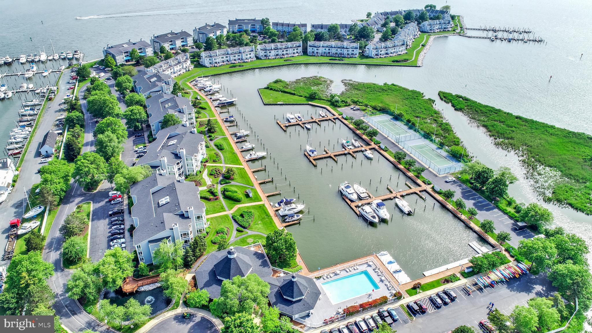 Welcome to this lovely 1st floor condo near the pool offering PANORAMIC WATERFRONT views and incredible indoor-outdoor living! Fabulous SUNSETS await you! Located on a deep-water, protected marina in the sought-after, gated community of Oyster Cove, this serene setting is perfect for a home office! ORIGINAL OWNERS bought this "MODEL" home from the builder. The contemporary design of this villa is unique and boasts angled walls for your pleasure. You will love the 4 walls of floor-to-ceiling windows in the great room. as well as the bright, OPEN floor plan with 9' ceilings. French doors lead into the kitchen featuring granite countertops, cherry cabinets,, stainless steel appliances and plentiful counters for hosting family/friend buffets. Primary suite has a large walk-in closet, updated bath with walk-in shower, double sinks plus a jacuzzi tub. Just outside the bath in an additional sink/vanity for your convenience. Enjoy the beautiful landscaping from your large, waterfront balcony with storage closet. A second bedroom provides wonderful light with 2 corner windows-great for an office! The 3rd bedroom has 2 closets! A 40' boat slip (M1VE06) is included directly behind the condo on the boardwalk. 5 guest slips are available for daily rentals for your visitors. Luxurious clubhouse features state-of-the-art gym and monthly socials offering a wonderful opportunity to meet your neighbors. Holidays parties, game nights and "Oyster Talks" are also offered for your entertainment. Enjoy a morning stroll on the 1.5 mile walking path along the water or a dip in the salt-water pool. The pool opens at 6AM so you can enjoy a swim before the heat of the day. This wonderful community also offers tennis/ pickleball/basketball, a kayak rack for >100 kayaks with launch platform, 10 jet ski ports, dog park and >100 boat slips ranging from 35' - 60'. Five guest slips are available for your visitors. Walk to 5 restaurants! Near 38-mile Cross Island Trail - great for biking, jogging, dog walking, etc. CHANGE YOUR ADDRESS AND CHANGE YOUR LIFESTYLE!
