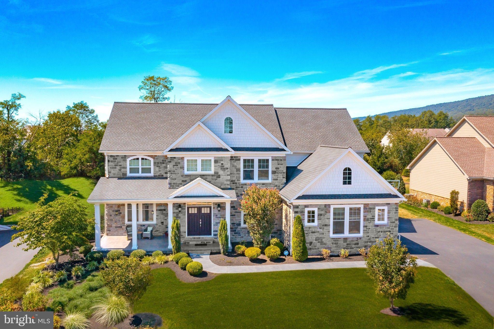 A Rare Opportunity to Own a Former Model Home in Cumberland Valley School District
Welcome to this exceptional 2016 former model, offering more than 5,700 sq. ft. of luxury living with premium upgrades, 4 (possible 6) bedrooms, 4.5 bathrooms, with fully finished basement. Built by renowned custom builder Tiday Homes, this residence blends modern functionality with timeless elegance.
Nestled in the foothills of the Blue Mountains, the home combines natural beauty and serenity with convenience, just minutes from major highways, grocery stores, restaurants, and community amenities. The exterior showcases stone and Hardie plank siding, architectural shingles, professional landscaping, and a flat usable backyard facing tree line.
A double-door entry opens to soaring 9-ft ceilings, hardwood floors, and two stunning stone gas fireplaces. Craftsmanship is evident in the coffered ceilings in the living and dining rooms (with shiplap in the living room) and tray ceilings in the primary suite, family room, and finished basement.
The gourmet kitchen is a chef’s dream and is a centerpiece for both daily living and entertaining, featuring an oversized Quartz island, Bosch appliances, upgraded cabinetry with pull-out hardware, pantry, vac pan and under-cabinet lighting. The owner’s suite features a sitting room with custom built-ins, spa-like bath with freestanding tub, quartz countertop, separate double vanities, free standing cupboards and a custom closet system. Additional bedrooms are also very spacious  with generously sized  walk-in closets—one en-suite and another with a private sitting area/study nook.
Designed for comfort and efficiency, the home offers energy upgrades, a smart thermostat, whole-house humidifier, and abundant natural light, quartz in two other bathrooms. Practical touches include an oversized mudroom with upgraded cabinetry and shoe closet, central vac, a first-floor office with built-ins, and a second staircase.
Entertaining is effortless with a welcoming front porch, poured/stenciled concrete walk and patio, recessed flood lighting, and an extended maintenance-free rear patio with built-in speakers. The three-car garage and utility rooms feature epoxy floors for durability and style.
The finished lower level, recently completed by the same builder flows seamlessly with the home and includes a full wet bar with microwave, dishwasher and beverage center, media room, exercise room, bonus room/bedroom/workshop, prayer/meditation room, storage rooms, coat closet and a Control4 smart theater with projector.
Meticulously maintained and significantly enhanced by the current owners couple of years ago who invested in a fully finished lower level, upgraded mudroom cabinetry, shoe closet, custom master closet by design, landscaping, and additional improvements. Every upgrade was chosen with care with the same builder to make sure it flows very well with the rest of the home and shows same craftsmanship.