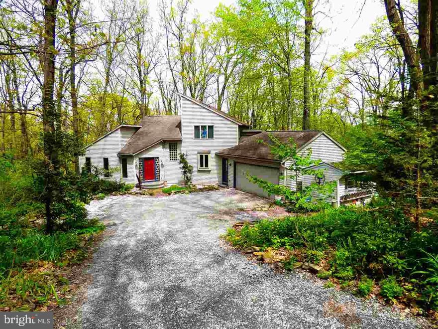 Secluded contemporary in lush woods yet close to grocery & shopping! Walking trails in woods! Airy one-of-a-kind home! Mature perennial gardens, lush bushes & trees.  Cath ceiling in Great Rm w/gas frplc, 2 brs & 1.5 ba on 1st flr, MBR on 2nd Flr w/pri balcony MBA & w/i closet, lighted glass block eik islnd, wine rack, 12x14 deck off DR, GEOTHERMAL hvac! Clean!
