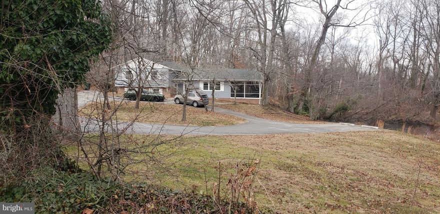 Beautifully Updated Split-Level Retreat on Nearly an Acre Along Route 50! Set back on a private, wooded lot just under an acre, this beautifully remodeled 3-bedroom, 2.5-bath split-level home offers the perfect blend of comfort, style, and outdoor enjoyment. A long circular driveway welcomes you home, setting the tone for the peaceful setting that surrounds this 2,676 sq. ft. property. Inside, the home has been thoughtfully updated since purchase, including new replacement windows, mini-splits, new paint, new LVP flooring, a fully remodeled bathroom, and a vapor barrier with insulated crawl space—providing both modern comfort and long-term peace of mind. The main level features bright, open living spaces with sliding doors from both the living and dining rooms leading to the screened-in porch. From here, you can relax while overlooking the serene pond and the inviting in-ground pool—an ideal setup for entertaining or unwinding after a long day. The finished lower level expands your living possibilities with a cozy den complete with a bar area, a utility/laundry room, and two bonus rooms that can easily be converted into a large fourth bedroom or additional sleeping quarters. Sliding doors from the den offer direct access to the pool area, creating a seamless indoor-outdoor flow. Additional highlights include a wood-burning stove, ample storage, and the flexibility to add 1–2 more bedrooms if desired. With professional photos coming soon, this move-in-ready home is sure to draw attention quickly. A rare combination of privacy, upgrades, and lifestyle amenities—this one truly won’t last.