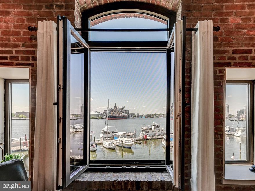 Enjoy true waterfront living at its finest in historic Fell’s Point! Perfectly positioned at the end of a charming cobblestone street, this beautifully appointed one-bedroom, one-bath residence in Henderson’s Wharf offers sweeping, unobstructed views of Baltimore Harbor from the living room, kitchen, and bedroom. This spacious, one-level condominium blends historic character with modern updates, featuring exposed brick walls,  wood flooring, and updated kitchens and baths with granite countertops. The thoughtfully designed layout includes a generously sized bedroom with a walk-in closet, creating both comfort and functionality. With approximately 1,043 square feet, this residence offers a rare opportunity to enjoy serene waterfront views while being just steps from the vibrant energy of Fell’s Point. One assigned garage parking space is conveyed with the unit for added convenience.
Residents of Henderson’s Wharf enjoy premium amenities, including 24-hour security and a fitness center. Located within walking distance to top restaurants, shopping, nightlife, and major hospitals, with easy access to I-83 and I-95, this home offers the perfect blend of tranquility and accessibility. Experience the best of waterfront city living in one of Baltimore’s most iconic neighborhoods.