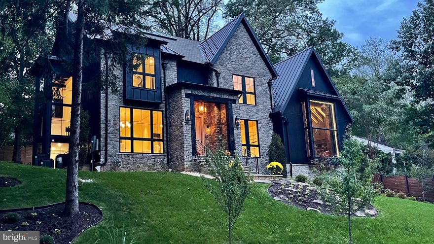 Introducing The Barn, a relaxed luxury by Artsy Homes, where timeless elegance blends effortlessly with refined comfort. A true expression of modern sophistication. From serene retreats in Washington, D.C. to countryside escapes reimagined in an urban setting, every detail of this home tells a story in the heart of Chesterbrook Woods, one of McLean’s premier neighborhoods.

The exterior captivates with meticulous craftsmanship. Twelve-foot beams at the front entrance complement intricate stonework, while a grand Canadian maple Andersen door exudes striking presence. French gas lanterns paired with RH light fixtures add refined charm. A metal roof blends seamlessly with premium architectural shingles, and the façade combines stone with Shou Sugi Ban siding, accented by thoughtful landscaping that completes this cohesive architectural statement.

At the heart of the home is a breathtaking thirty-foot-high lounge crowned with sixteen-foot windows, featuring a reclaimed roof rafter from 1847, salvaged from the last cotton mill of Virginia, that invites cascades of natural light throughout the day. The room, wrapped in century-old rugged heart pine and dark textured brick, carries a stillness that resonates deeply. Exposed roof rafters meticulously wrapped in birch wood add organic warmth to the soaring volume and create a space where serene grandeur meets quiet storytelling. Suspended above, the Arcachon Round brass chandelier anchors the room with rhythmic grace. Below, a custom-built fireplace framed by built-in bookshelves offers both intimacy and presence.

The kitchen is an artful composition of form, light, and texture. A ten-foot brass-textured waterfall countertop exudes understated charm, while sun-filled windows invite the day’s shifting moods. The Fulcrum Pendant, with its hand-blown glass and brass, hovers sculpturally, casting a gentle glow. Limestone walls evoke the Tuscan countryside’s earthy timelessness. Chevron white oak floors, soft-toned cabinetry, and polished brass hardware from the Camden Collection, inspired by mid-century French and Italian design, blend quiet confidence with craftsmanship. Reclaimed beams paired with structural I-beams create a dialogue between history and modernity, making the kitchen a celebration of refined restraint and comfort.

A slatted ceiling designed and constructed onsite guides you toward the dining area with a rhythm that feels intentional and fluid. There, a Tiered Rectangular Chandelier from the Marignan Collection, composed of more than one thousand crystal elements, takes center stage. Its interlocking formations float effortlessly, casting a shimmering cascade of light that fills the space with quiet drama.

The Thaddeus Powder Room collection, inspired by the surreal artistry of Salvador Dalí and Diego Giacometti, features hand-forged metals, a bespoke custom sink, and refined fixtures that intertwine with effortless sophistication, resonating with the home’s cohesive aesthetic. (This offers just a glimpse of the main level, with even more to explore throughout the home.)

At its core, Artsy Homes believes every house should tell a story, with each space unfolding as a meaningful chapter that endures over time, crafting environments that awaken reflection and wonder, where elegance and beauty invite you to slow down, breathe deeply, and embrace the true essence of feeling at home.