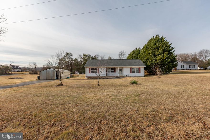 Set off a great cul-de-sac, 9408 Stonegate Lane boasts a thoughtfully-maintained, three-bedroom, two-bath rambler that balances a total sense of privacy with everyday comfort! Tucked in the Stonegate Village community (minutes from major routes!), the home sits on a tranquil lane where traffic is minimal and the surroundings feel worlds away. Stonegate Village features a low-cost HOA – the association maintains common areas including grass cutting near the community pond, which is stocked for fishing and adds to the neighborhood’s charm! Out front, the paved driveway and walkway lead to a small porch and an enclosed carport workshop. The yard is mostly open green space with minimal trees, offering flexibility for future landscaping. A privacy fence on one side enhances the secluded feel.  Out back, the concrete patio has been converted from a pergola into a fully covered structure for shade. There is a fenced neighbor boundary, tucked-away gardening area used for seasonal planting, a shed with ramp for lawn equipment and a chicken coop and run that can accommodate up to 12 chickens. Exterior updates include a new roof, gutters and downspouts installed in 2021. The vinyl siding is crisp white with maroon shutters, a white front door and white porch bannisters. Stone accents and a large front mulch bed offer a blank canvas for personal touches. Inside, the home follows a split bedroom design that works especially well for daily living! The primary suite occupies its own side of the house, creating a true retreat, while two additional bedrooms and a full bath sit down the hall on the opposite side.  Hardwood floors run through the main living spaces and secondary bedrooms, with wood-look LVP in the dining area and laminate flooring in the primary bedroom for durability and ease. The family room welcomes you in and is partially divided from the kitchen and dining room, giving the space an open feel while still defining each area. Sliding glass doors off the dining room lead directly to the backyard, making indoor-outdoor flow easy for everyday happenings. The kitchen connects to a dedicated laundry and pantry area, adding functionality without sacrificing space. Mechanically, the HVAC system and water heater are in good working order.  With its private setting, functional layout and move-in ready condition, 9408 Stonegate Lane offers an easygoing lifestyle with room to grow – all central to Fredericksburg, Orange and Culpeper.