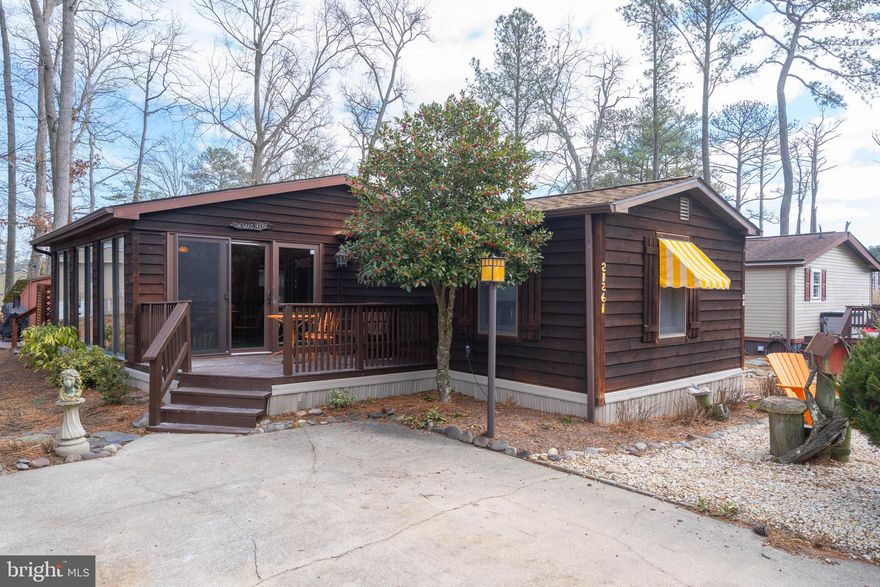 Welcome to this warm and inviting 2 bedroom, 2 bathroom coastal retreat offering 1,114 square feet of comfortable living space in Rehoboth Bay MHP. With beautiful cedar siding and a freshly stained deck, this home's charming curb appeal immediately feels welcoming. The true heart of the home is the stunning sunroom — a light-filled space with rich wood ceilings, skylights, and walls of windows that bring the outdoors in. Whether you’re enjoying your morning coffee, hosting summer dinners, or relaxing with a book on a breezy afternoon, this space is designed for making memories. It’s the kind of room that becomes everyone’s favorite place to gather. Inside, the home offers an easy, functional layout with spacious living and dining areas that flow comfortably together. The kitchen provides ample cabinetry and counterspace, perfect for everyday living or weekend entertaining. Recent updates offer peace of mind, including a roof and HVAC system both just 4 years old, along with freshly stained cedar siding and decks. Located in the waterfront community of Rehoboth Bay, residents enjoy access to a bayfront pool, marina, boat ramp, playgrounds, tennis courts, and scenic picnic areas — all just minutes from the beaches, boardwalk, dining, and shopping of downtown Rehoboth Beach. Full of warmth, character, and years of cherished memories, this home is ready for its next chapter — whether as a year-round residence or your perfect beach getaway.