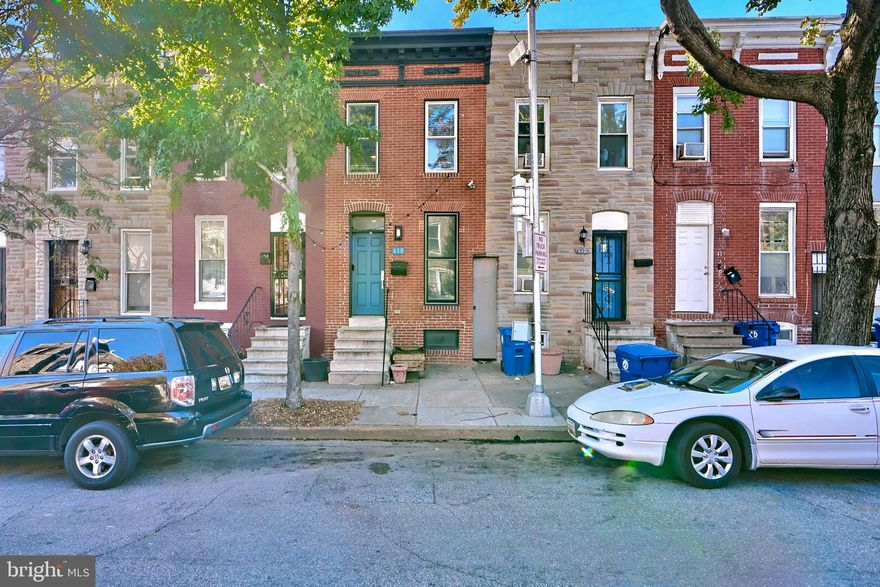 Beautifully renovated townhome in the vibrant McElderry Park neighborhood, just a short walk to the renowned Patterson Park. This urban gem boasts lush green spaces, towering trees, paved walking trails, historic battle sites, a lake, playgrounds, athletic fields, a swimming pool, and the Instagram-worthy Patterson Park Observatory. Also nearby, you will find Eager Park, which features a playground and splash pad that are perfect for summer use, Johns Hopkins Hospital, Fells Point, Broadway Market, and a Starbucks. Upstairs, the home features 2 bedrooms and a fully updated bathroom with custom tile work. The main level is connected by a stunning split-level staircase leading to gleaming hardwood floors and recessed lighting throughout the living room, kitchen, and dining area. The living room showcases newly added built-in shelving near the front door, providing both functionality and aesthetic appeal, complemented by elegant crown molding. The kitchen impresses with stainless steel appliances, granite countertops, a gas stove, and stylish new cabinets. Downstairs, the fully finished basement offers a versatile 3rd bedroom or additional living space. Step outside to your own private backyard urban oasis, complete with shade sails, a privacy fence, a beam for a swing, and custom planter boxes. Behind the home, you'll find access to a community garden for just $20 per year - a rare find in the city. Conveniently located with easy access to downtown, the county, I-83, and I-95, this beautifully renovated townhome is a must-see. Schedule your appointment today!