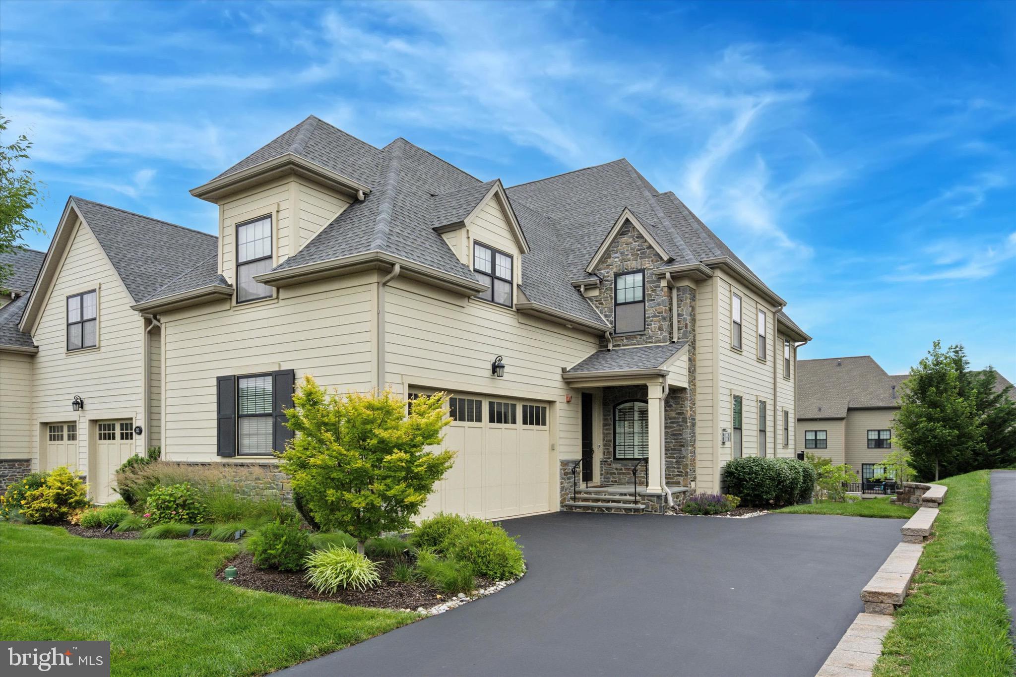 Welcome to 204 Pelham Ct. in the Reserve at Creekside – the area’s premier luxury carriage home community. Set on a quiet cul-de-sac, this stunning end unit Springfield model offers over 4,300 square feet of beautifully designed living space across three finished levels. With 3 bedrooms, 2 full and 2 half baths, this exceptional home combines flexible living spaces, thoughtful upgrades and designer finishes. A gracious foyer with a dramatic two-story staircase opens to the main level with hand-scraped hardwood flooring throughout. The spacious living room features crown molding and a corner gas fireplace and flows into the adjacent formal dining area with crown molding and chair rail. The gourmet kitchen showcases white cabinetry, granite countertops, stainless steel appliances, and a large center island—perfect for entertaining and family gatherings. Sliding glass doors lead to an extended rear deck with views of the backyard. A private office with French doors offers a quiet retreat or an ideal work from home space. A conveniently located powder room and access to the oversized two-car garage complete the main floor. Upstairs, the luxurious primary suite features a cove ceiling, an oversized walk-in closet plus two additional closets and a spa-style bathroom with dual vanities and a large frameless glass shower. Two additional generously sized bedrooms, a full hall bath, and a laundry room with custom cabinetry complete the upper level. The finished lower level adds versatile living space, ideal for a media room, home gym, or additional office, and includes a half bath for convenience. Additional upgrades include recessed lighting, ceiling fans, custom shutters and window treatments, an irrigation system, covered sprinkler heads, and a custom slate front porch with stone steps. The Reserve at Creekside offers the ideal lifestyle – maintenance free living with luxury amenities, including a 4,500 sq. ft. clubhouse with fitness center, gathering room, kitchen, and outdoor pool with flagstone patio. Located minutes from Fort Washington and Wissahickon Parks, the shops and restaurants of Flourtown and Chestnut Hill and easy access to routes 309, 476, and the PA Turnpike. A rare opportunity to own a move-in ready home in one of the area’s most sought-after communities.