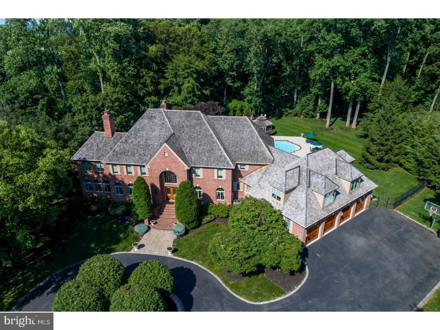 A circular driveway trimmed in Belgium block welcomes you to this one of a kind executive residence. 1265 Old Woods is the best real estate offering in the Delaware Valley. Designed by renowned architect Ann Capron, the floor plan is brilliant and includes the classic features you expect and unique ones that make it extraordinary. This superior property is unlike anything you have seen before. The combination of size, quality, architecture, privacy and location make it a once in a lifetime opportunity. Nowhere else can you find almost 10,000 square feet, all brick, oversized heated 4 car garage, 4 fireplaces and 2 by 6 construction with opportunities to make it even larger! The uses are endless including multi-generational, live in nanny or caretaker, or simply enjoy it all for yourself. The main level is highlighted by the gourmet kitchen complete with 10 burner Jenn-Air in the island, double oven, updated appliances, complete butler's pantry, Rutt custom cherry cabinets and beautiful granite counters. Other highlights are the peaceful solarium, sunroom, large office with handsome built-ins, 2 fireplaces and multiple access points to the new veranda, upstairs and basement. The huge master suite is the show piece of the upper level. It's the owner's happy place with a sitting room, 2 sided fireplace, luxurious master bath and dual walk in closets. This level is completed by 4 additional bedrooms and 3 full baths. The finished walk out basement space is larger than some area single homes! It has 2 game areas, family area with brick fireplace and wet bar, bedroom, gym and ample storage. Step outdoors to your very own resort with a roman style 52 by 26 newly renovated pool, expanded decking great for entertaining, gazebo and huge veranda overlooking it all. The perfectly flat lot is enhanced by professional landscape architecture creating unmatched privacy. If you value quality and quantity, your search ends here. There is so much more to tell you in person so call today for a personal tour.