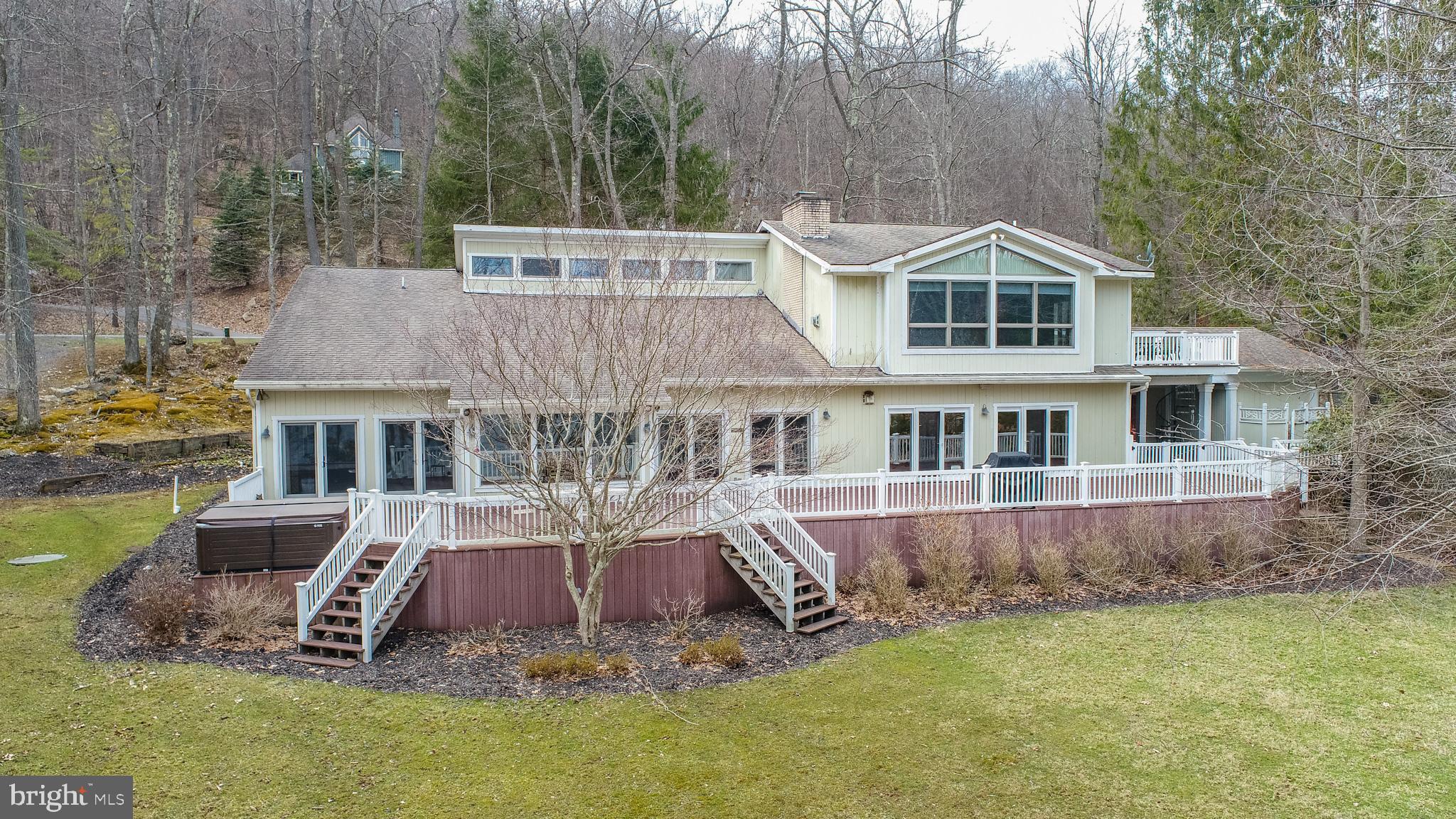 This stunning Deep Creek Lake waterfront home offers an unparalleled lakeside living experience with 200 feet of prime lakefront and a private Type A dock. Located just down the street from the base of Wisp Resort, this property is ideally positioned for those seeking both a tranquil retreat and easy access to year-round outdoor activities. Boasting over 5,000 square feet of living space, this home offers generous room for both family and friends to enjoy.
Upon entering, you are greeted by two grand family rooms, each designed to take full advantage of the breathtaking natural light and sweeping lake views. These spacious areas provide a perfect setting for relaxation, entertaining, or cozying up by the fire. The large kitchen is a true centerpiece of the home, with ample counter space, high-end appliances, and plenty of room for preparing meals while enjoying the company of loved ones. Adjoining dining areas offer perfect spots for both casual meals and more formal gatherings.
For outdoor enthusiasts, the full-length lakefront decking provides an exceptional space for entertaining or simply enjoying the beauty of Deep Creek Lake. Whether you're hosting a summer barbecue or taking in a peaceful afternoon, the views from this expansive deck are nothing short of spectacular. The private Type A dock allows for direct access to the lake and is permitted for 2 powered boats and 1 non-powered boat, making it easy to enjoy water sports, fishing, or just relaxing and swimming off of the dock.
The home’s bedroom configuration is as impressive as its living spaces. The master suite offers a serene retreat with stunning lake views and a spa-like en suite bathroom. Additionally, there is a smaller master suite on the main floor, perfect for guests or multi-generational living. Upstairs, you'll find a set of Jack and Jill bedrooms as well as a 5th bedroom on the top floor, offering privacy and a quiet escape.
Situated on Marsh Hill Road, this home offers the perfect balance of privacy and convenience. With Wisp Resort just moments away, you have access to skiing, snowboarding, hiking, boating, and golf, making this a prime location for outdoor enthusiasts. Whether you're seeking a permanent residence, a vacation getaway, or an investment property, this waterfront gem provides everything you could want in a Deep Creek Lake home.