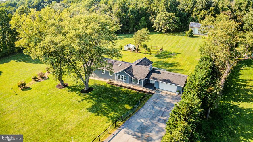 Welcome to 5619 Riggs Road, a beautifully renovated CUSTOM designed rancher nestled on 4 serene and fully fenced acres just minutes from downtown Gaithersburg and Olney.   As you enter, you'll love the private foyer - separated "just enough" from the main living areas of the home to afford wonderful privacy. The open floor plan offers an open living room that is anchored by a cozy wood-burning fireplace, with luxury vinyl flooring extending throughout the home. The dining area is spacious and light-filled - ideal for entertaining and large gatherings or lending itself beautifully to more intimate get togethers. The large kitchen boasts a generous island with a breakfast bar, quartz countertops, stainless appliances, and 2 skylights offering more natural light making it  simply perfect for creating not only culinary masterpieces, but weekly meal prep.  Located off the kitchen is a delightful sunroom. Whether used for a home office, sipping your favorite beverage while gazing out onto your land or play space, this room is certain to add to all of the enjoyment of this fine home! To complete the upper/main level, you'll find 2 bedrooms and 2 full baths, including an exceptionally spacious primary bedroom with a fabulous walk-in closet and a luxurious en suite bath in addition to a hall bath with a deep soaking tub.   The fully finished lower level of this home includes a fantastic rec room with a 2nd wood burning fireplace, an additional bedroom measuring 25x13, a full bath, and a mud room with laundry that will be the envy of friends and family, alike!  You are able to exit to the side yard from this level, as well.   Throughout the home, energy efficiency has been first and foremost in the design and remodel.   This home features an oversized attached 2-car pass-through garage, plus a detached workshop/garage with solar panels (owned, not leased) and space for 8+ vehicles (with water and electric connections), offering endless possibilities for a workshop, home business and extra storage.   Nature lovers will appreciate the tranquil setting backing up to 78 acres of natural forest, where you can enjoy fox, wild turkeys and deer. The home's prime location on an emergency route ensures reliable snow removal and power year-round. For outdoor enthusiasts, the house is conveniently close to shopping and amenties in nearby (and quaint!) Olney, as well as all that Gaithersburg has to offer, Rachel Carson Park and Blue Mash Park, with hiking trails, golf courses, and popular local breweries nearby.   This home and property offer an unsurpassed rare blend of modern living, energy efficiency and tranquil surroundings, all in a gorgeous bucolic setting! Includes two parcels!   ***   New HVAC (3 units) 2022, New deck 2022, New septic tank 2021, New doors 2021, New roof 2021, New kitchen and appliances 2021, New LED interior lighting 2021, New attic insulation and aero sealed all duct work, Energy Star program through PEPCO, Water heater 2021, New windows 2020  **  Water and electricity to workshop/garage!