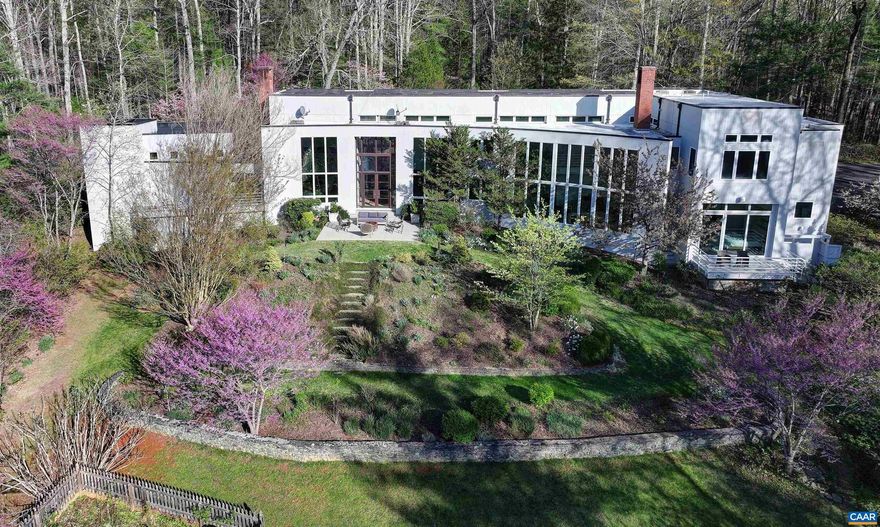 MECHUM BANKS DRIVE - Spectacular year round Blue Ridge Mountain views from this premier property in Ivy. The architecturally designed residence, masterfully showcases the breathtaking views from many rooms inviting the outdoors inside and providing awesome natural light. Spanning 6,690 finished square feet, the main level encompasses foyer; living room w/ fireplace; eat-in kitchen with high end appliances adjacent to family room w/ fireplace; spacious game room; main primary suite; mudroom; laundry & two car garage complete with chargers. Upstairs is a second primary suite, three bedrooms and two full baths. Throughout are indoor gardens, desk areas and tucked away storage. Current owners have meticulously maintained the property along with many upgrades such as solar panels, custom energy efficient shades with remote control and generator. Each season brings with it a new light and ambience. Situated on 8 acres fronting on the Mechums River, mature gardens and shrubs accent the natural setting along with a tennis court. It is truly unique to be able to retreat to such an extraordinarily tranquil home only minutes west from the activity and  amenities offered by University of Virginia and Charlottesville.,Granite Counter,Fireplace in Family Room,Fireplace in Living Room