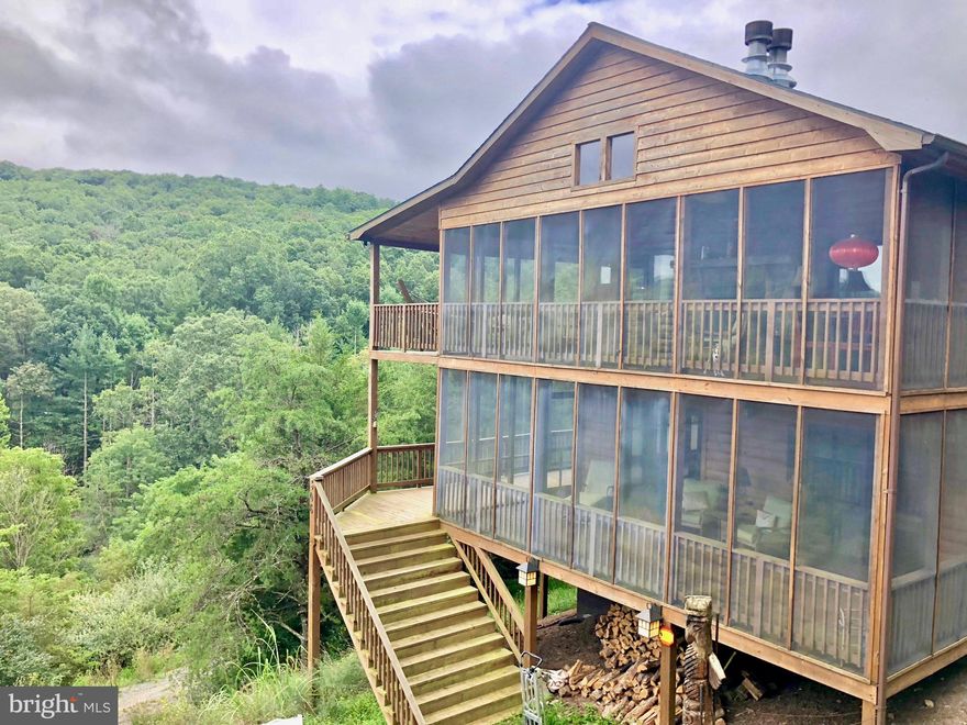 Amazing 3BD/2BA Cabin on 5.01 AC in the heart of Lost River Valley.    Large open grand room on top level with  wrap around decks and screened porches with panoramic mountain views.   Extra windows  and skylights in cabin bring in the outdoor light and views.  Indoor stone fireplaces in grand room and screened porch of grand room are perfect for gathering with friends.  Lower level has three bedrooms and 2 full baths.  Amenities include wood floors, wood vaulted ceilings, stainless appliances, marble counters in kitchen and bathroom.  Slate flooring in hallways and bath.  High speed fiber optic at the property.  Extensive hardscaping. Minutest to all the amenities of dining and entertainment.