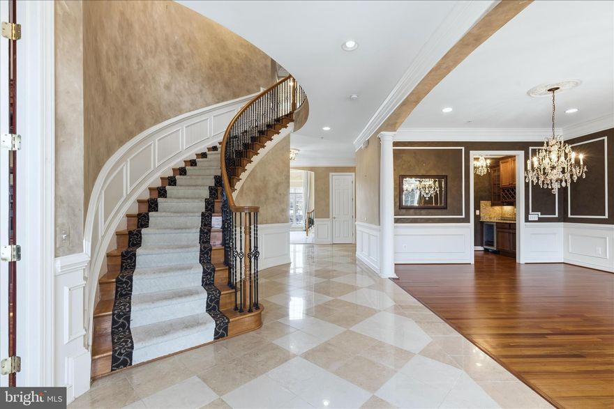 Welcome to your new home.  A distinguished Stone-front former model estate on an idyllic 2+ acre corner lot in one of Potomac’s most coveted neighborhoods. This extraordinary residence blends timeless elegance with thoughtful design, offering expansive space for both everyday living and grand entertaining.

Step inside to a dramatic curved staircase and gleaming marble floors that set the tone for the refined finishes throughout. To your left, a library with rich cherry wood built-ins provides the perfect study or retreat. Sunlight pours into the tucked-away sunroom with wall-to-wall windows and a cozy fireplace, creating a bright yet intimate space to relax. Flow into the magnificent double-story family room, where towering windows fill the space with natural light.

The heart of the home is the chef’s dream kitchen; featuring top-of-the-line appliances, a dual-level granite island, abundant counter space, a walk-in pantry, and a built-in coffee bar. Adjacent is a window-lined breakfast room overlooking the private patio, ideal for casual mornings and summer gatherings. For added convenience, a secondary full service kitchen sits discreetly behind the main space.

Beyond the main level, discover a versatile au pair or in-law suite above the garage with a bedroom, walk-in closet, full bath, living/dining room, and an efficiency kitchen; perfect for guests or multigenerational living. A truly unique bonus is a separate suite with a private entrance, office, and high ceilings, offering flexibility for work-from-home or guest accommodations.

Upstairs, five generous bedrooms each include full en-suite bathrooms and walk-in closets, showcasing custom finishes throughout. The owner’s suite is a private sanctuary featuring a cozy sitting area with fireplace, dual walk-in closets with built in closet systems, and a spa-like bath. Step out to the rear-facing covered terrace.. a serene spot to unwind and overlook lush, private views.

The finished lower level expands your living space with another kitchen, a full bedroom, bonus room with indoor sauna, large open recreation area, and a temperature-controlled wine cellar. A professional media room ensures unforgettable movie nights, and ample unfinished storage adds practicality.
Ready to make this dream yours?
