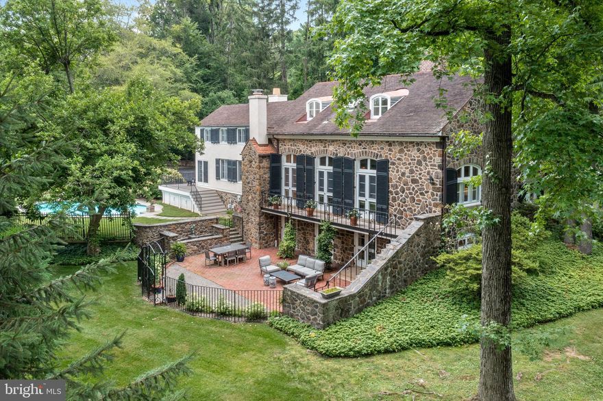 Beautifully updated stone home featuring 5 bed, 3 full and 2 half baths in Easttown township. Situated on 1.8 private acres with gated entrances this classic home began its journey to today as the 1886 "Easttown School" school house. The space was converted to a residence in 1930 and subsequently expanded with a show-stopping, newly updated kitchen/great room and luxurious first-floor owners' suite with steam shower, radiant heat flooring, custom cabinetry, walk-in closet, and designer features. From the gracious main entrance, you will encounter large living and dining spaces with soaring windows and 11 ft ceilings, perfect for hosting family and friends or the intimacy of evenings in front of the fire. the Upper level finds 4 generously-sized bedrooms and two remodeled baths. The newly remodeled lower level abounds with timeless comforts, two additional fireplaces, radiant heat floors, wet bar, large butler pantry, den, family room with direct access to the ground level patios, oversized workshop/storage area, mudroom, laundry room and three-car garage. The outdoor spaces are designed to seamlessly integrate indoor and outdoor with direct access to ipe wood decks, brick and stone patio, and heated pool. Beautifully landscaped gardens and yards designed for privacy complete this classic Main Line oasis!
