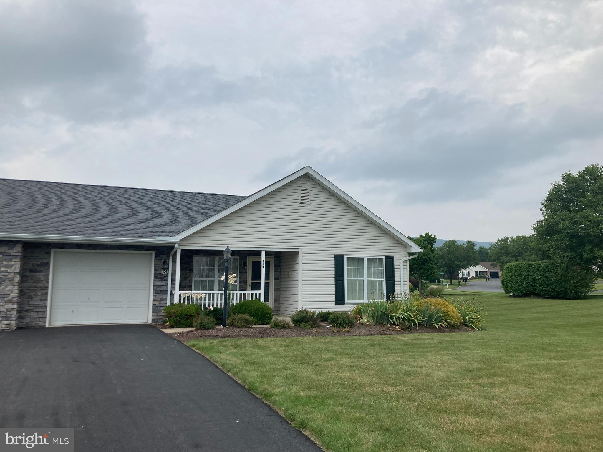 Rare opportunity to own a home in Penns Manor. Well maintained corner unit with a formal dining area that boasts a beautiful stone fireplace, and door to patio, where you can sit and enjoy the scenic view of the mountain! Primary bedroom suite with accessible shower and lower vanity, linen closet and vinyl flooring. Open floor plan with large living/kitchen area, separate laundry/mud room off the garage and two spacious bedrooms. Covered front porch with professional landscaping. Community center for residents use. These properties do not come up often so don't delay! Schedule your tour today!