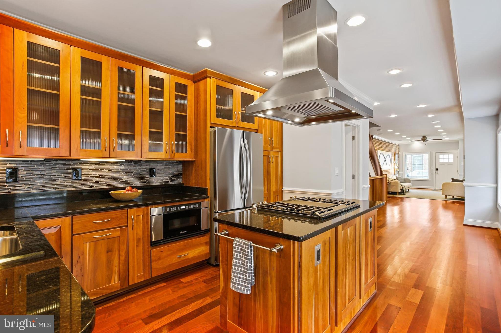 Welcome to 501 S Decker Avenue! Nestled on a quiet street just steps from all that Patterson Park and Canton have to offer, this end-of-group stunner boasts over 2,600 square feet of beautifully finished living space, with sweeping park and city views from the recently upgraded Trex rooftop deck (2024). The main level features gorgeous cherry hardwood floors, an open-concept living and dining area, and a chef’s kitchen equipped with glass cabinetry, granite countertops, stainless steel appliances, a large island with cooktop, breakfast bar, and a separate dining area. A built-in Bose speaker system fills the home with your favorite music or podcasts. Abundant natural light and a convenient half bath complete the main level. The fully finished lower level offers great flexibility with a half bath and walk-in closet—perfect for a guest suite or home office. Upstairs, you’ll find two spacious primary bedroom suites, each with walk-in closets and luxurious en-suite bathrooms featuring walk-in glass showers, granite vanities, and one with a jetted soaking tub and double sinks. The laundry room includes a full-size washer and dryer with a deep utility sink for added convenience. From the upper level, an interior staircase leads to a massive rooftop deck, perfect for entertaining or relaxing with skyline and park views. Additional highlights include a Nest doorbell with audio/intercom, Nest camera out back, alarm system wired to windows/doorways/roof, a central vac, intercom, dual-zoned HVAC systems (2008 & 2009), a new hot water heater (2022), and a new roof (2024)—all offering efficiency and peace of mind. Located just blocks from Hampstead Hill Academy, Patterson Park, tennis courts, the pool, Creative Alliance, Matthew’s Pizza, and some of Baltimore’s best dining, this is city living at its finest—with easy on-street parking always available.